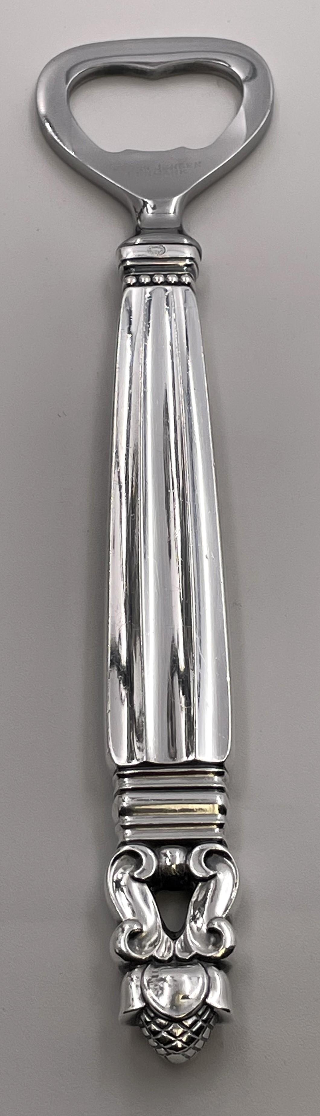 Apribottiglie a barra in argento sterling di Georg Jensen con il celebre motivo della ghianda. Misura 6 1/2'' di lunghezza e reca i marchi come mostrato.

L'argentiere danese Georg Jensen (1866-1935) avviò la sua attività nel 1904 a Copenaghen. La