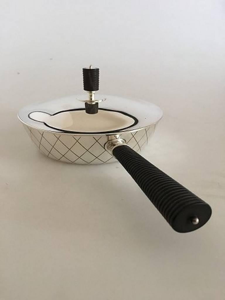 Georg Jensen sterling silver skillet, designed by Bernadotte pattern #909, in Art Deco style and with a wooden finial on cover. Measuring 10.7 inches long, 6.6 inches wide, and 3.7 inches tall. Weighing 17.5 troy ounces. Bearing hallmarks as shown