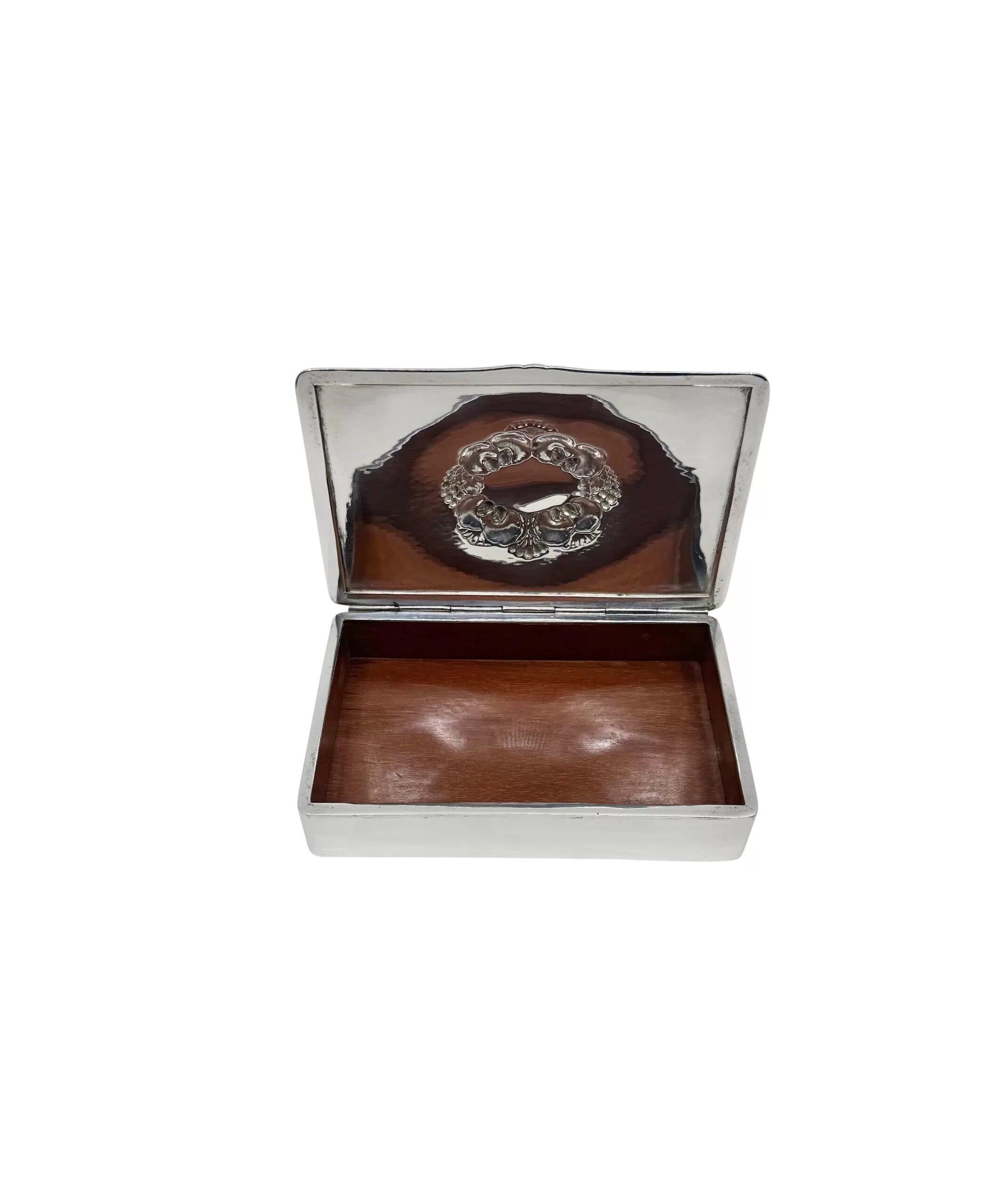 Caja Georg Jensen vintage de plata de ley con forro interior de madera, diseño nº 507A de Gundorph Albertus de 1927. Caja rectangular de plata de ley martillada. Tapa ligeramente arqueada con ornamentación floral estilizada. Interior con base y