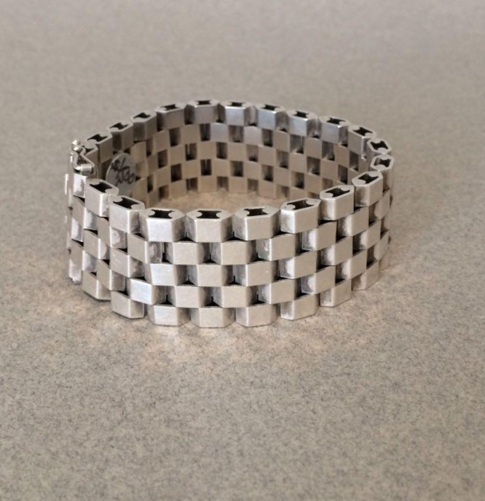Georg Jensen Sterling Silver Bracelet by Ernst Forsmann No. 191.

 

Spectacular 'checker-board' visual created by intricate, alternating squares of sterling silver. This bracelet lays smoothly and shapes beautifully to the wrist. 

 

A similar
