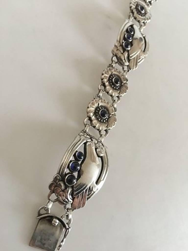 Georg Jensen Sterling Silver Bracelet No 23 with Birds and 10 Synthetic Sapphires. Measures 18 cm / 7 3/32 in. Weighs 39 g / 1.40 oz. From after 1945. In beautiful condition.