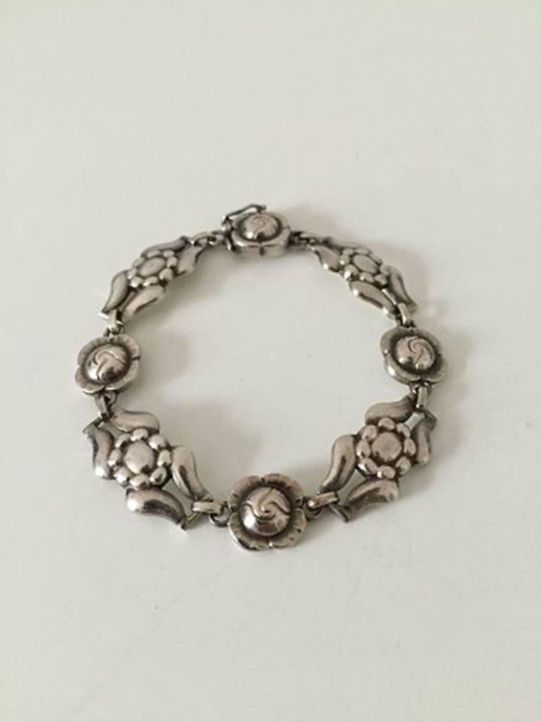 Georg Jensen Sterling Silver Bracelet with Flower Links No 18. With marks from 1933-1944

Measures 18 cm / 7 3/32 in. x 1.4 cm wide / 0 35/64 in. Weighs 21 g / 0.75 oz.