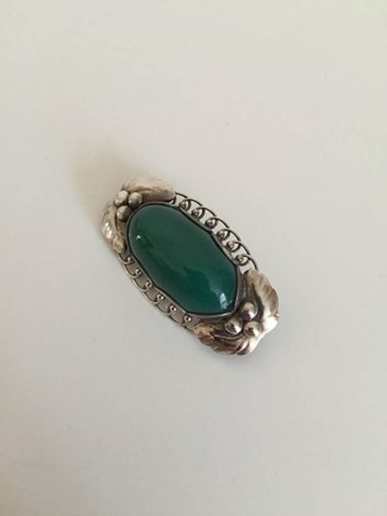 Georg Jensen Sterling Silver Brooch #223 with Green Agate. From after 1945.

Measures 4 cm long, 1.5 cm wide (1 37/64 in. x 0 19/32 in.)