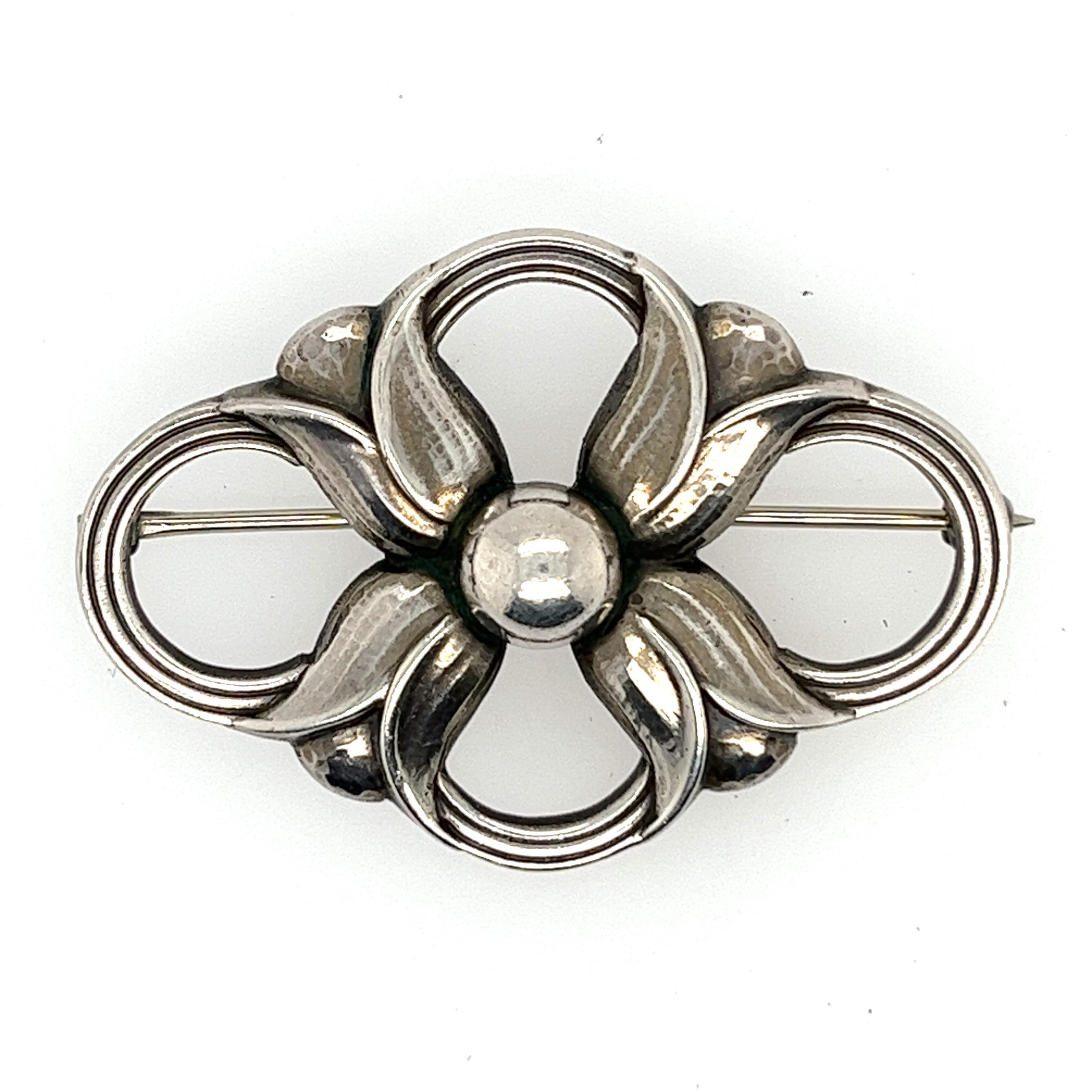 Georg Jensen was a danish silversmith and designer, he achieved international prominence for his commercial application of modern metal design. This beautiful brooch is a unique piece from this artist. Crafted of sterling silver with an intricate