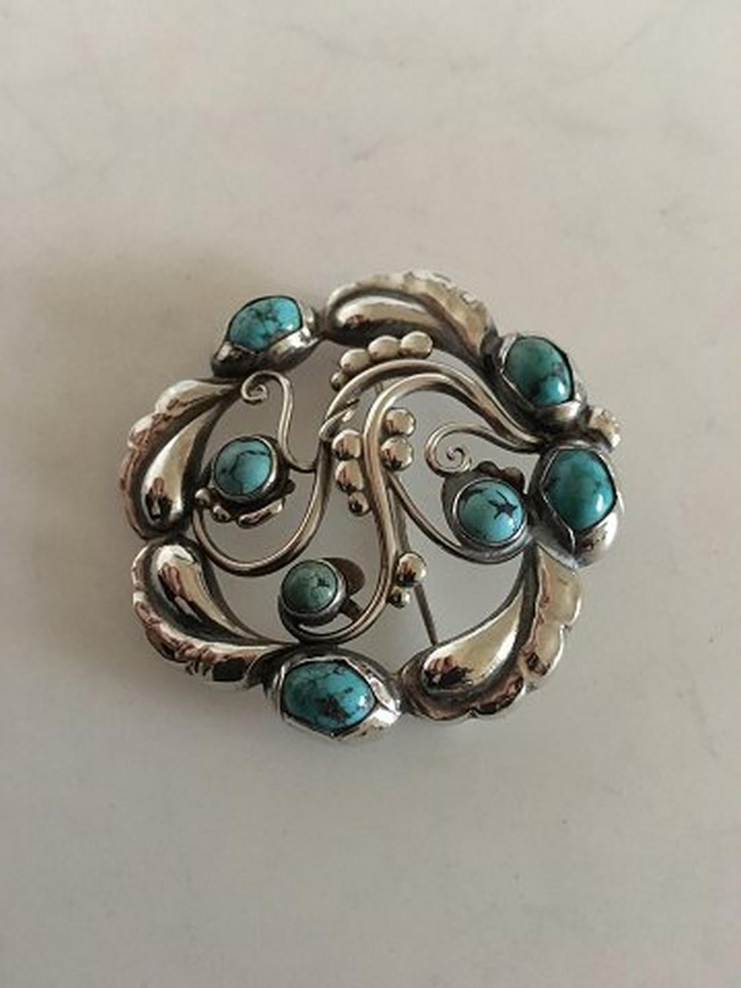 Georg Jensen Sterling Silver Brooch No 159 ornamented with Turquoise. Measures 4.6 cm / 1 13/16 in. diameter. Weighs 17 g / 0.60 oz. Manufactured after 1945.