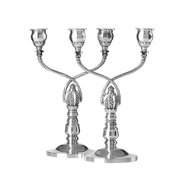 A Pair of Early Decorative Georg Jensen Two-Light Candelabra #343. Designed in 1920 by Johan Rohde, this exquisite pair of two-light candelabra exemplifies the refined elegance of early 20th-century silver craftsmanship. The gracefully curved arms