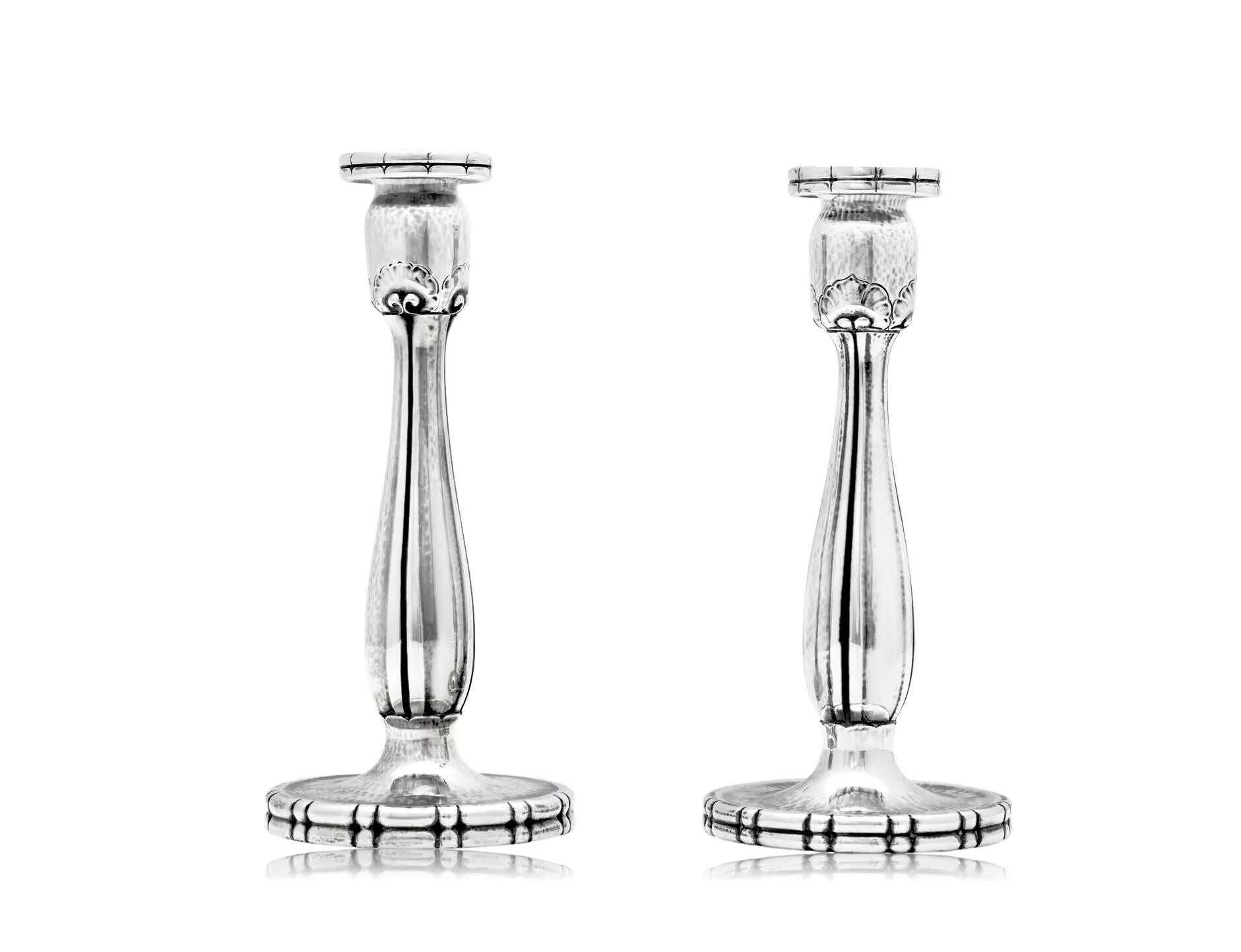A pair of Early Georg Jensen sterling silver candlesticks, design #119 by Georg Jensen from 1917. The intricate hand chasing on these candelabra is exceptional, which makes them rarer and less frequently seen on the open market. The round, slightly