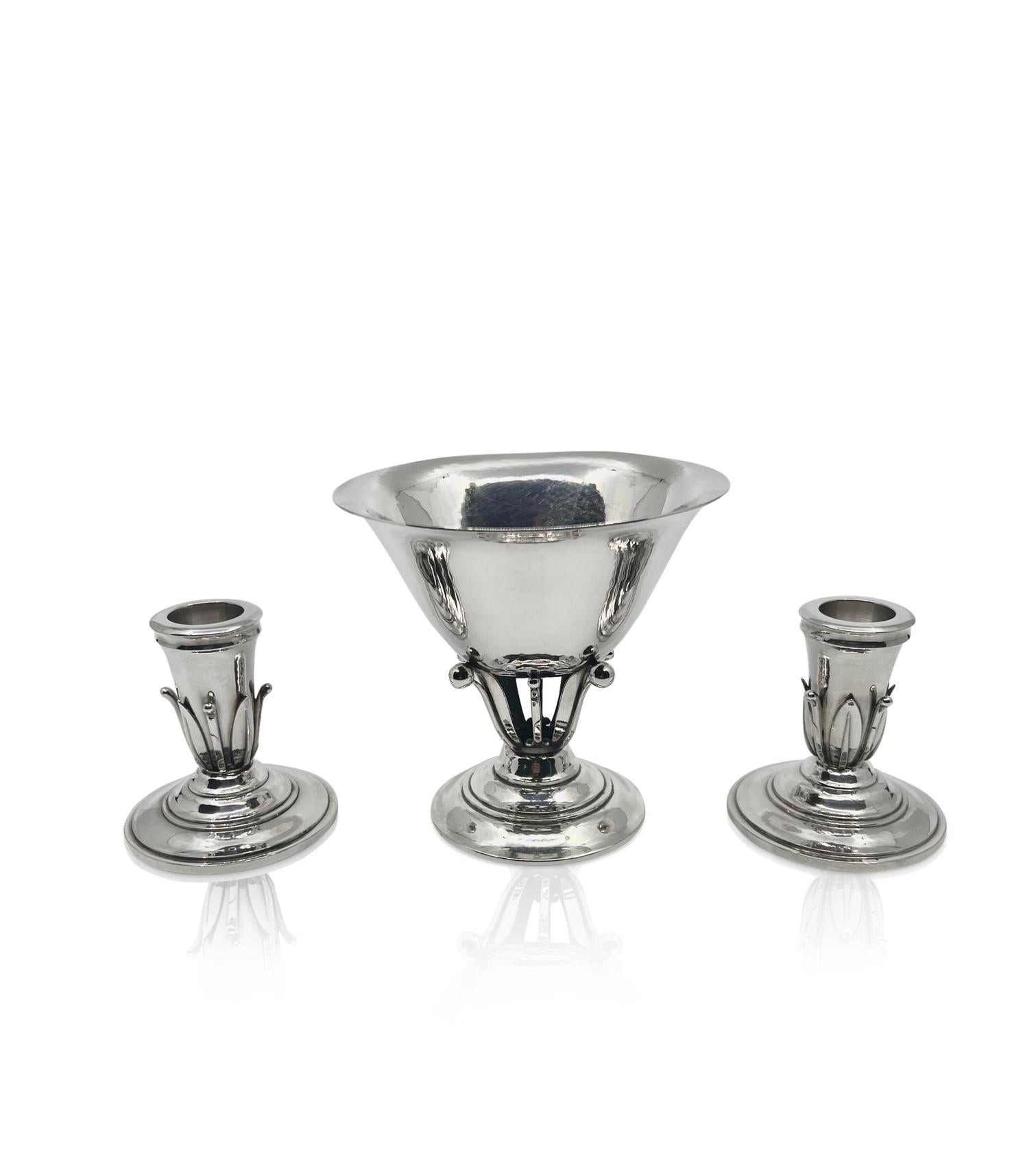 A pair of small Georg Jensen sterling silver candlesticks, design #612 by Johan Rohde from the late 1920s. These match Georg Jensen Johan Rohde small bowl #17. Round base slightly hammered surface and four leaves and stems mounted on each