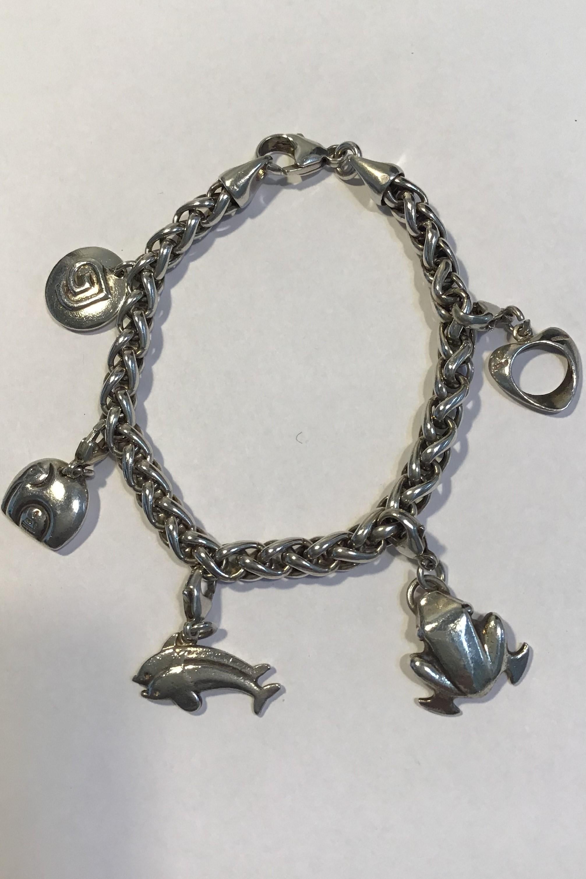 Georg Jensen Sterling Silver Charm Bracelet. With charms: Frog, Elephant, Dolphins, a Henning Koppel Heart and a Georg Jensen Logo . 

Measures 20.5 cm L (8 5/64