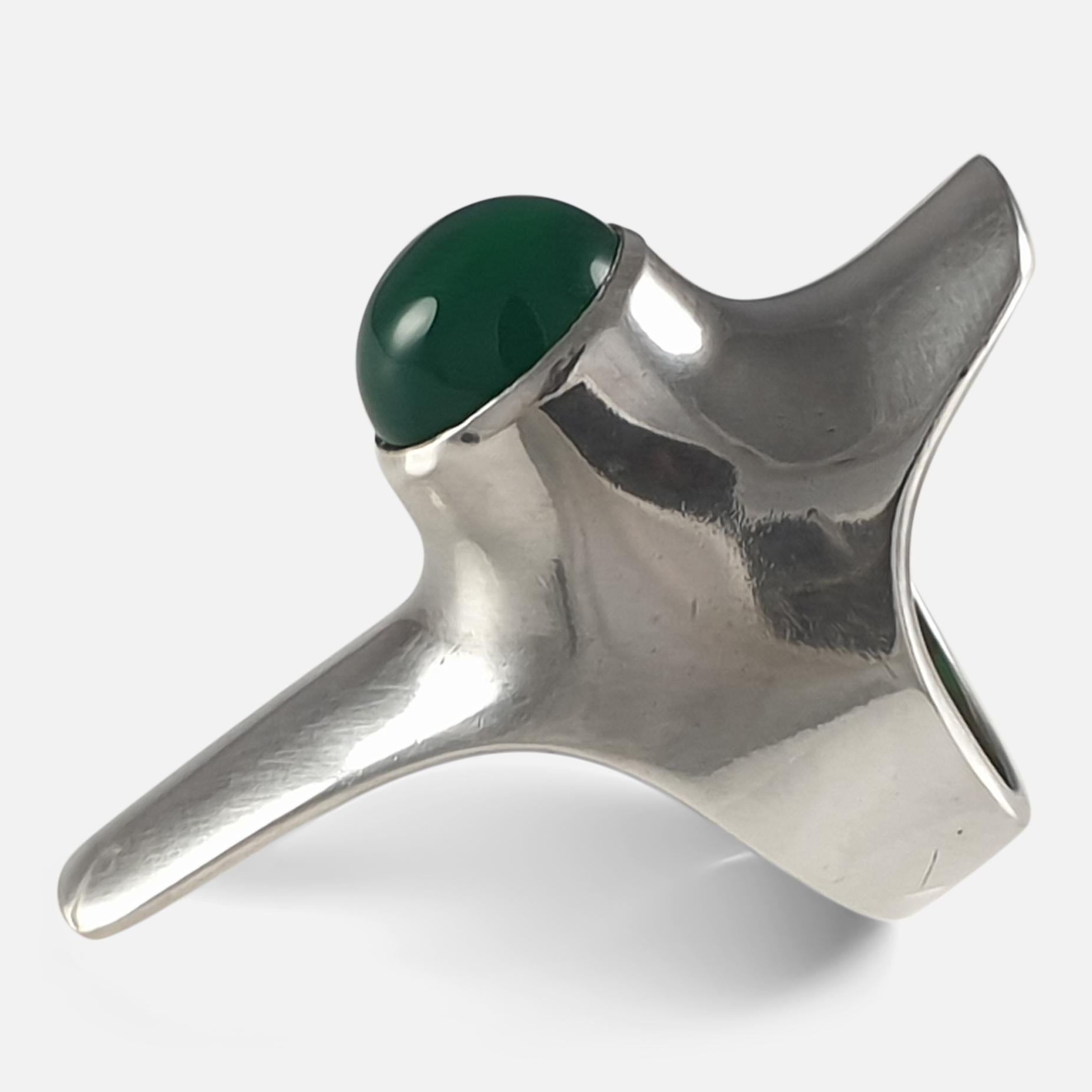 A Georg Jensen sterling silver and Chrysoprase modernist ring, design #154 by Henning Koppel. Stamped Georg Jensen within dotted oval mark, '925 S', 'Denmark', & '154'.  

The ring is UK hallmarked, 925.

Period: - Late 20th Century.

Engraving: -