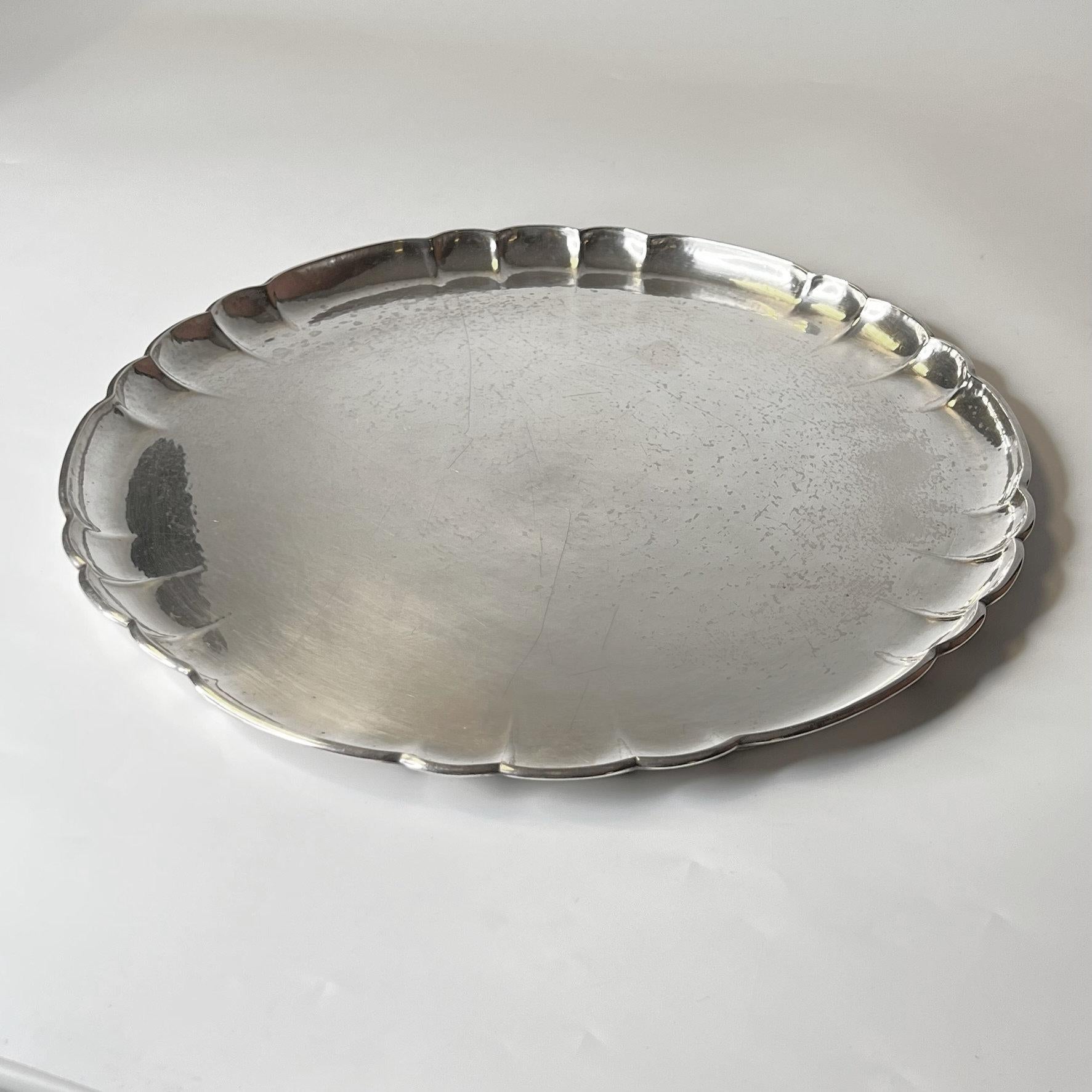 Our circular sterling silver platter from Georg Jensen dates from circa 1930 and is in good condition, with a handful of scratches. Measure: 14.5 inches (36.8 cm) across.