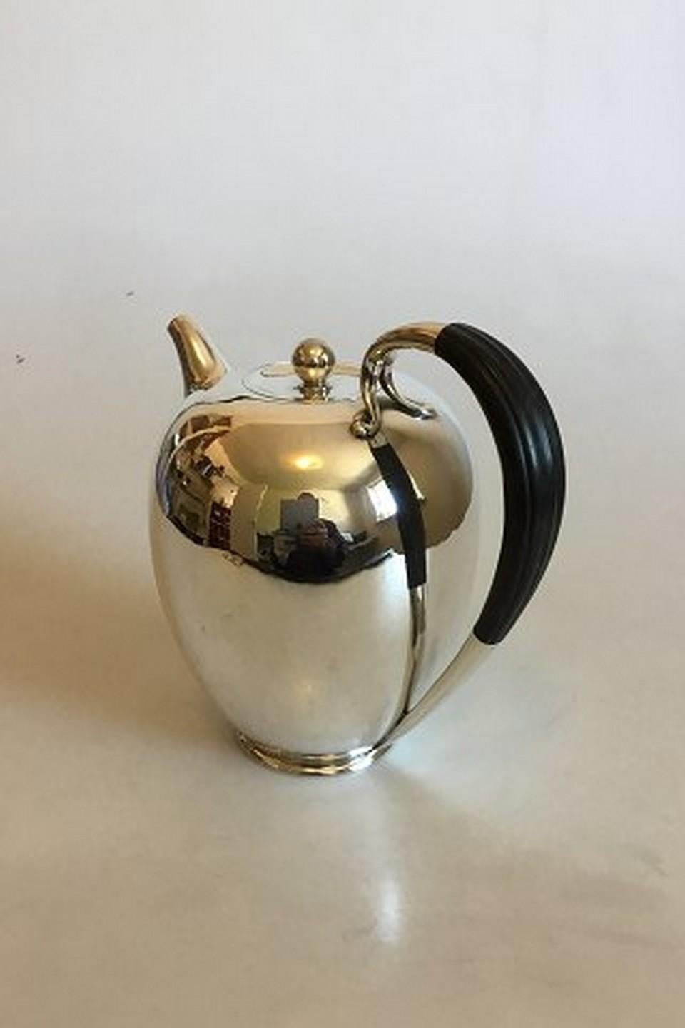 Georg Jensen sterling silver coffee pot no. 787 with handle og black wood.
Measures: 17 cm / 6 11/16 in. x 17 cm / 6 11/16 in.
Weighs 573 g / 20.25 oz.
Item no.: 336516.