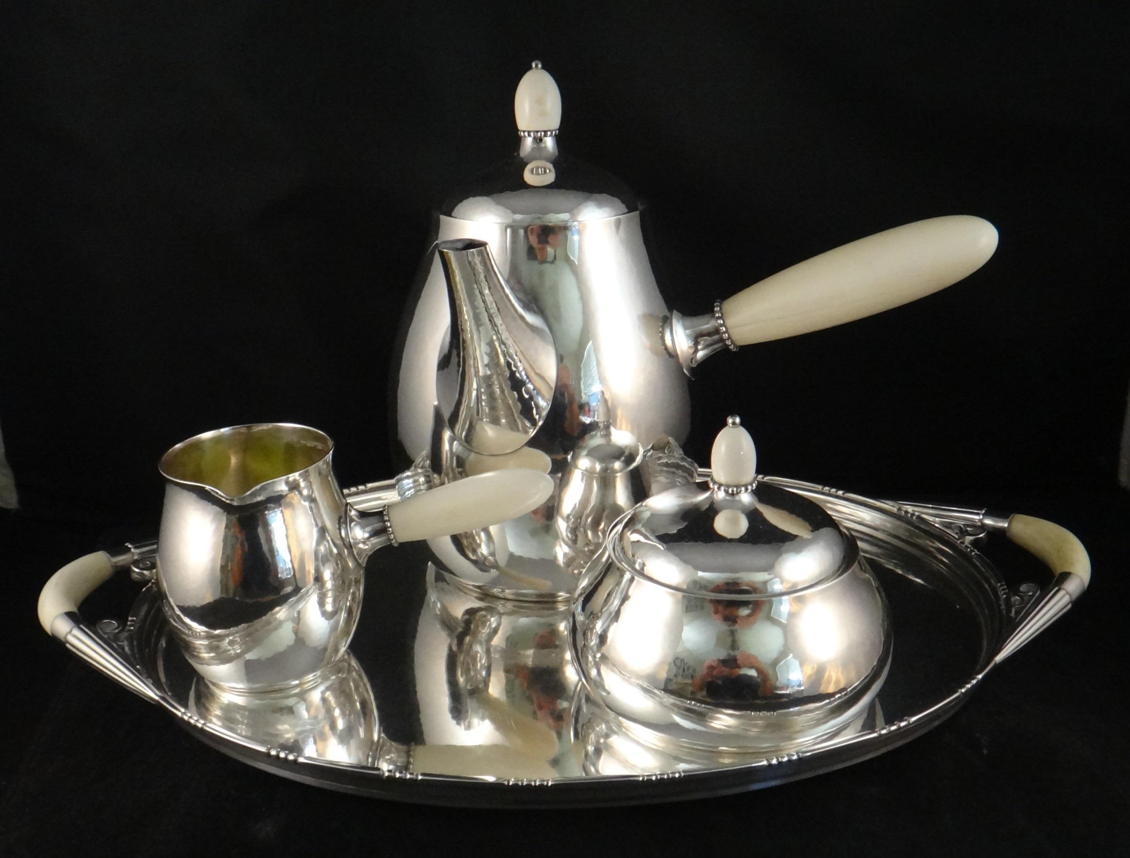 Late 1940's George Jensen sterling silver four piece coffee set. Art Moderne Design. Set includes the sterling silver tray, coffee pot, covered sugar bowl, and creamer. Each piece fully marked (see photos).
Dimensions listed below are for the
