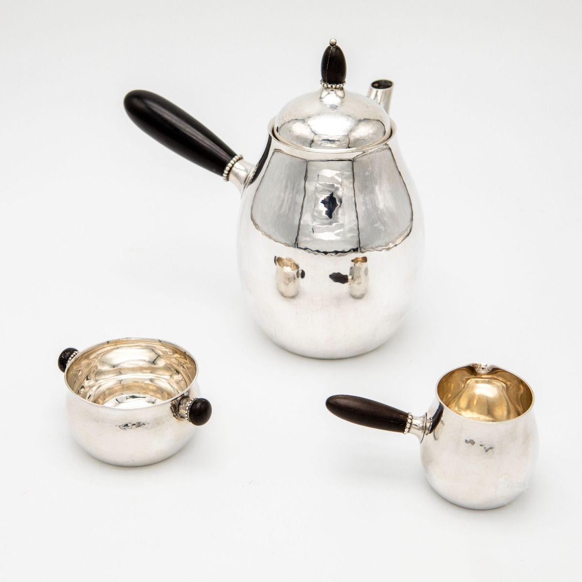 Elegant service à café conçu par Georg Jensen (1866-1935) vers 1915. Fabriqué en argent sterling avec des poignées en bois dur.

Ce modèle est un bel exemple des premiers travaux d'orfèvrerie de Georg Jensen et a été produit à l'orfèvrerie de Georg