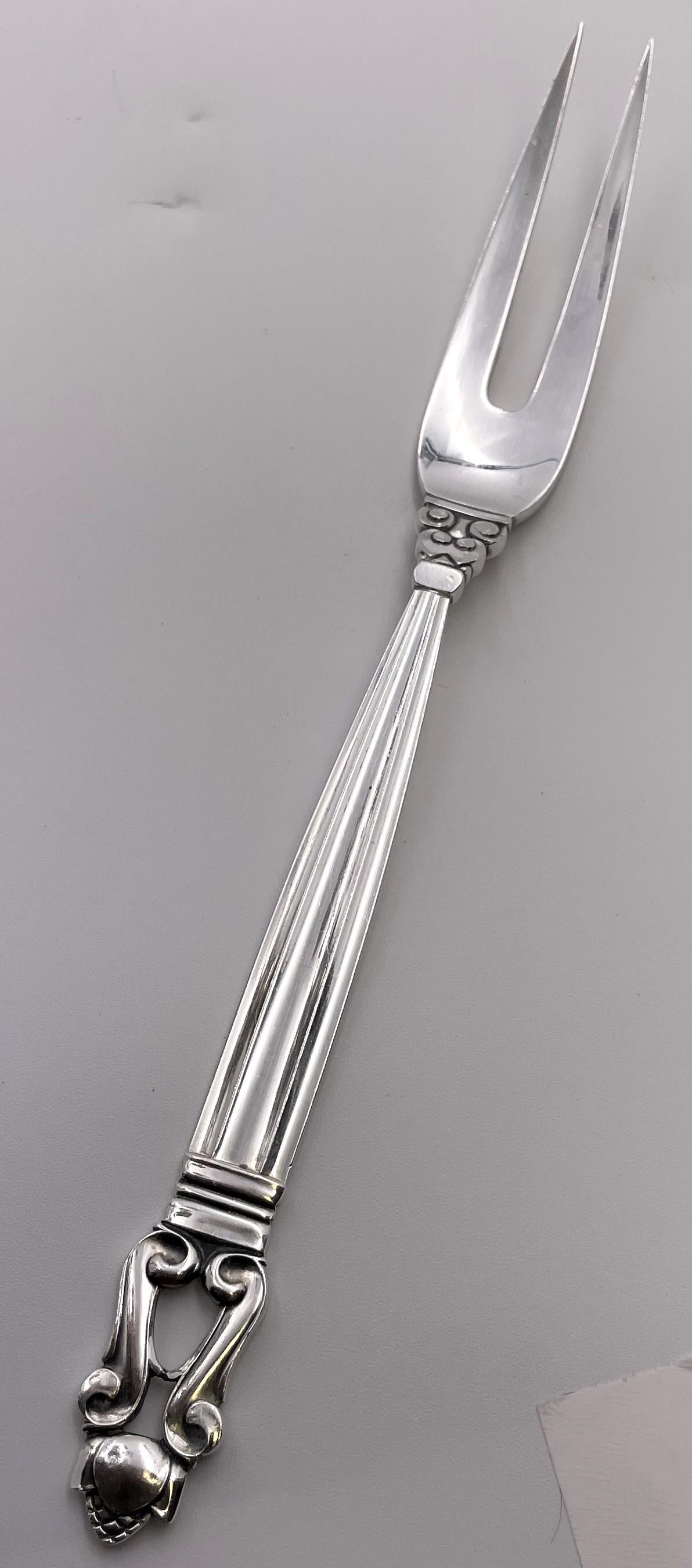 Forchetta per carne fredda di Georg Jensen in sterlina con il celebre motivo della ghianda. Misura 8'' di lunghezza e reca i marchi come mostrato.

L'argentiere danese Georg Jensen (1866-1935) avviò la sua attività nel 1904 a Copenaghen. La