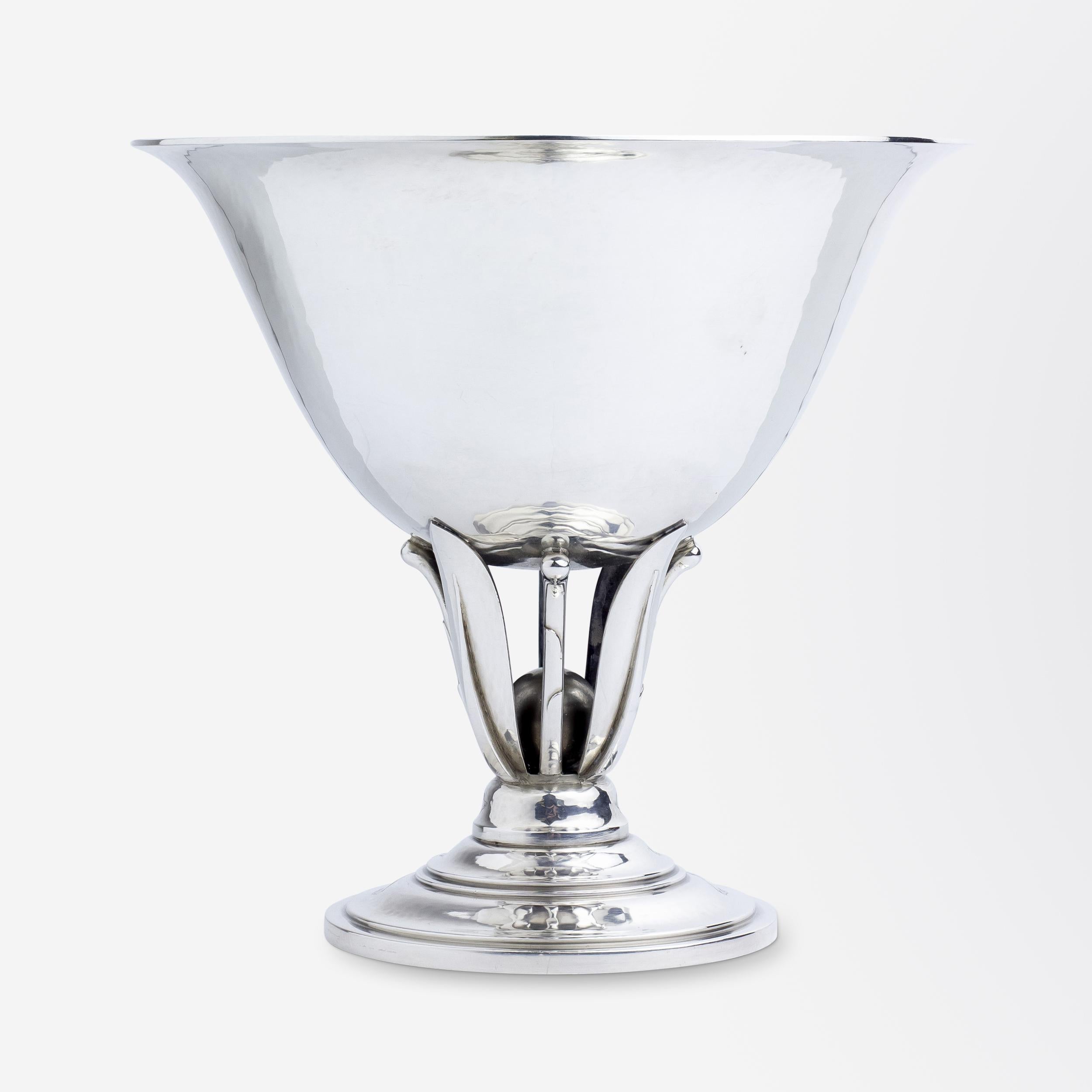 An elegant sterling silver comport designed by Johan Rohde (1856-1935) for Georg Jensen known as model #590. The hand hammered bowl is braced by delicate floral inspired elements, leading to a sphere contained in its centre. To the underside the