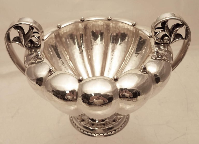 Sterling silver open sugar and creamer by Danish maker Georg Jensen. Designed in a repetitive lobed body, with upturned handles, furled leaves within handles, and beading around opening. Pattern number 479B. Measurements: open sugar 4 1/3 inches