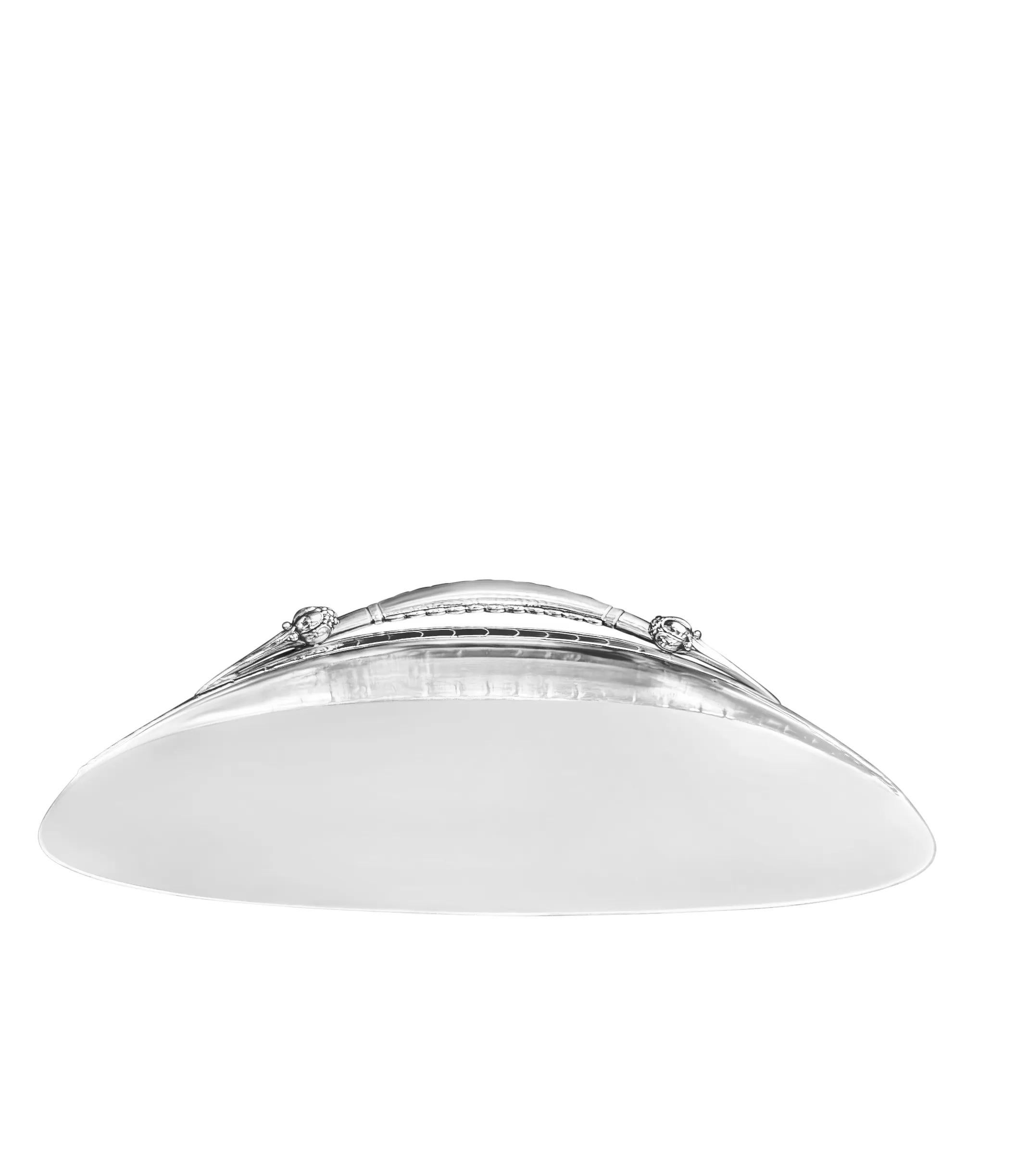 Rara bandeja recogemigas Georg Jensen martillada a mano en el modelo Ornamental nº 38, diseñado por Georg Jensen hacia 1912. Esta elegante bandeja plana presenta una parte superior curvada forjada a mano y un asa hueca adornada con dos bulbos