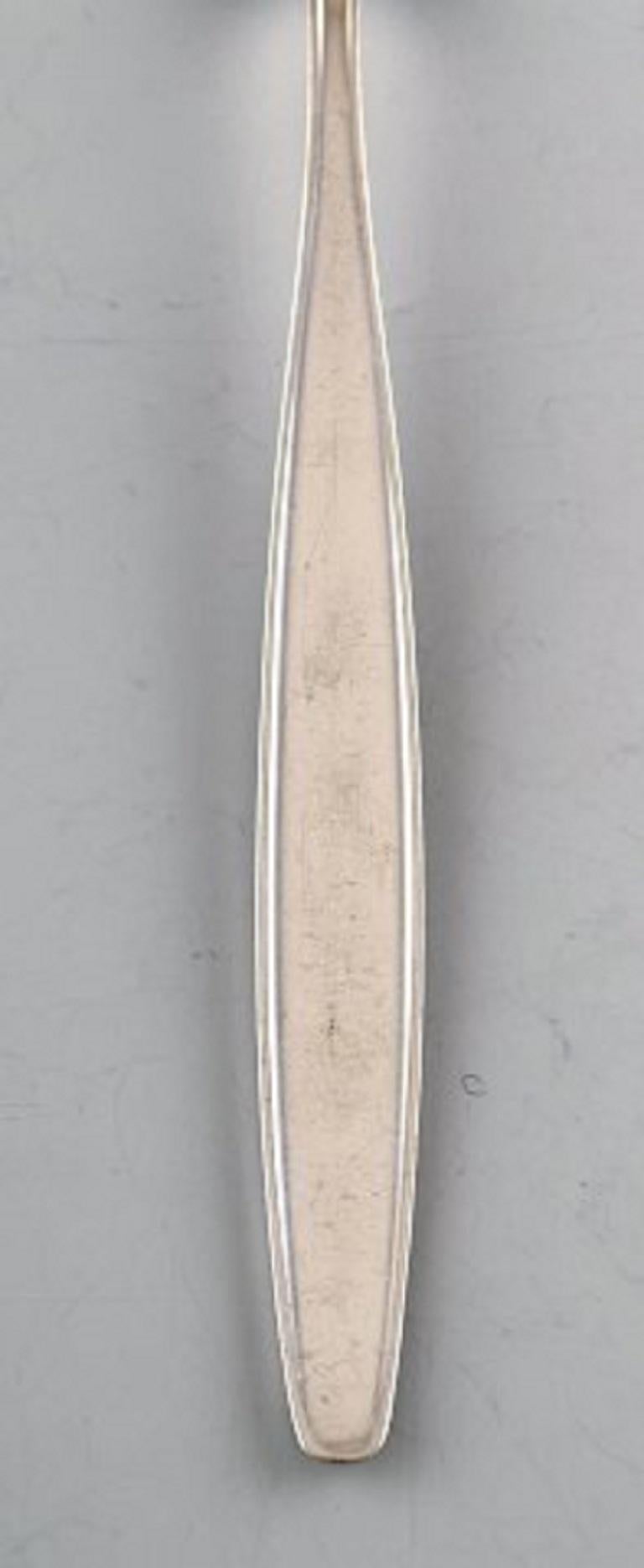 Georg Jensen sterling silver cypress lunch fork.
Measures: 19 cm.
In perfect condition.
Stamped.
Designed by Tias Eckhoff 1952-1953 For Georg Jensen Silversmith, Denmark. Cypress pattern no. 99.
4 pieces in stock.