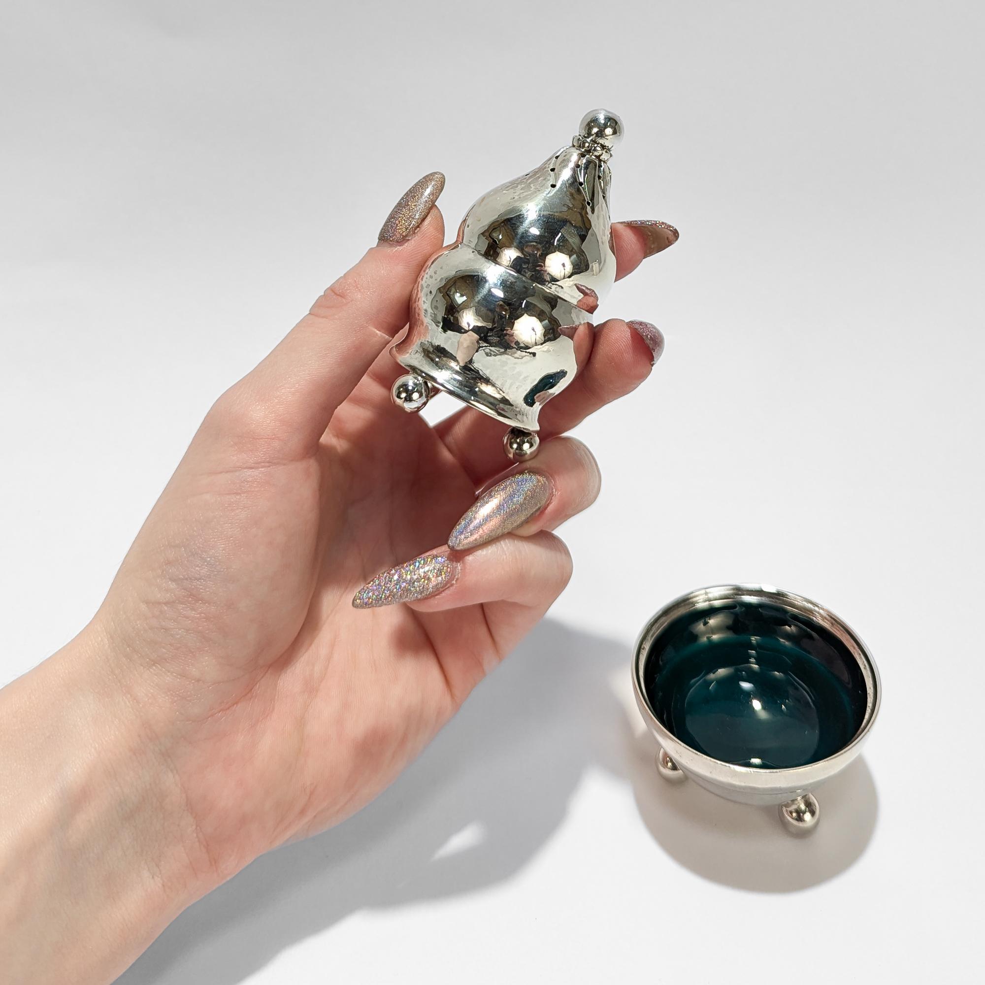 Un ensemble de sel et de poivre en argent de style moderne danois.

Par Georg Jensen.

En argent sterling.

Modèle n° 410.

Comprenant une poivrière et une salière avec un bol émaillé vert foncé. Tous deux sont soutenus par 3 pieds à rotule