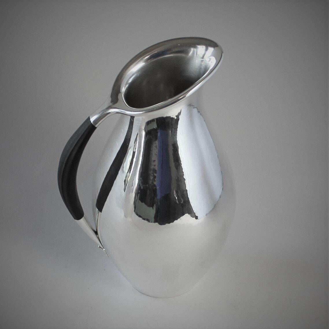 Georg Jensen sterling silver large pitcher with ebony handle, No.432F by Johan Rohde.

Holds 82 ounces.

A similar example can be seen in the book Georg Jensen Holloware, The Silver Fund Collection by David Taylor and Jason Laskey, pg
