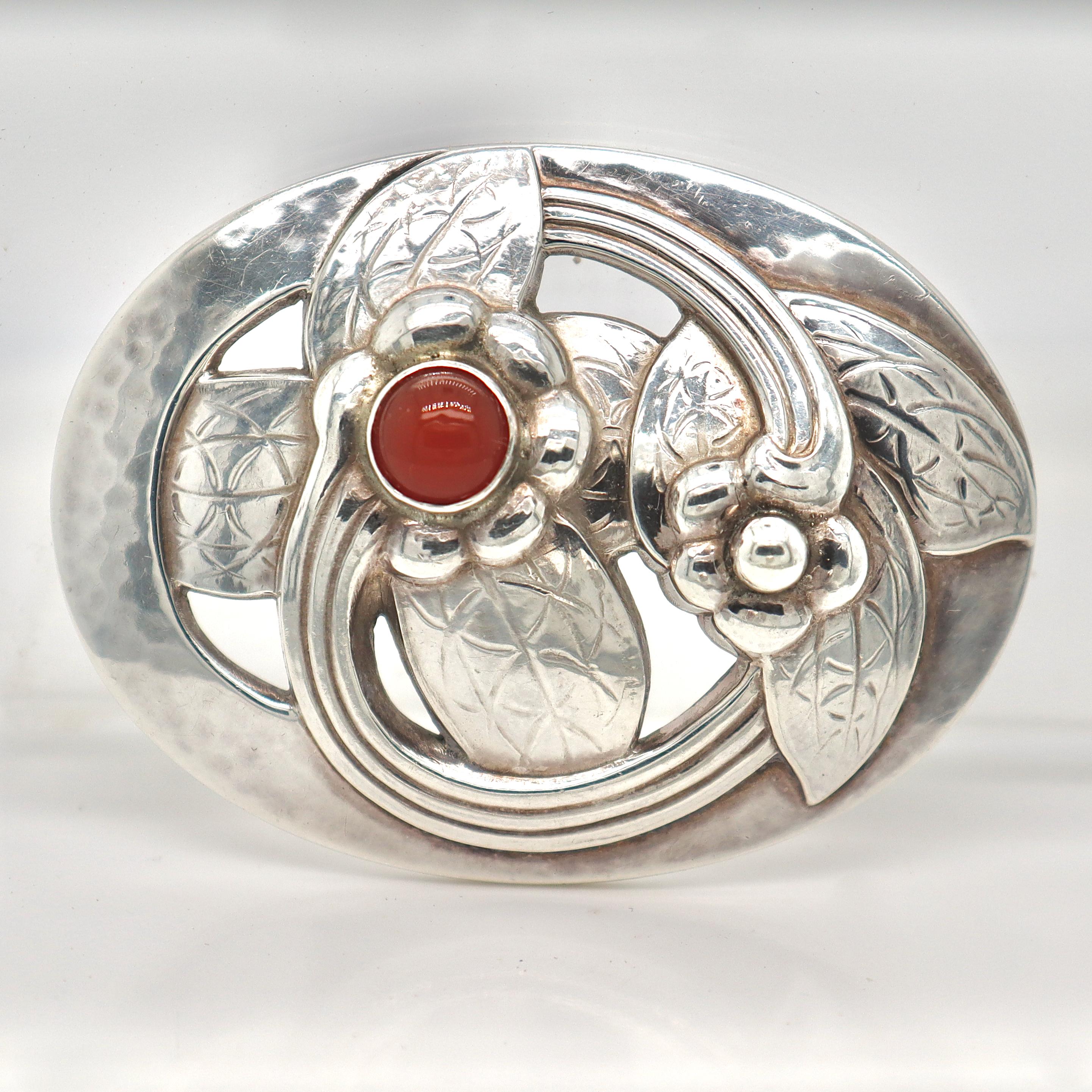 A fine Georg Jensen sterling silver brooch.

Model no. 13. 

In the form of a floral brooch with an amber or carnelian cabochon.

Designed by Georg Jensen.

Simply a wonderful brooch from one of Denmark's premier silversmiths!

Date:
20th Century,