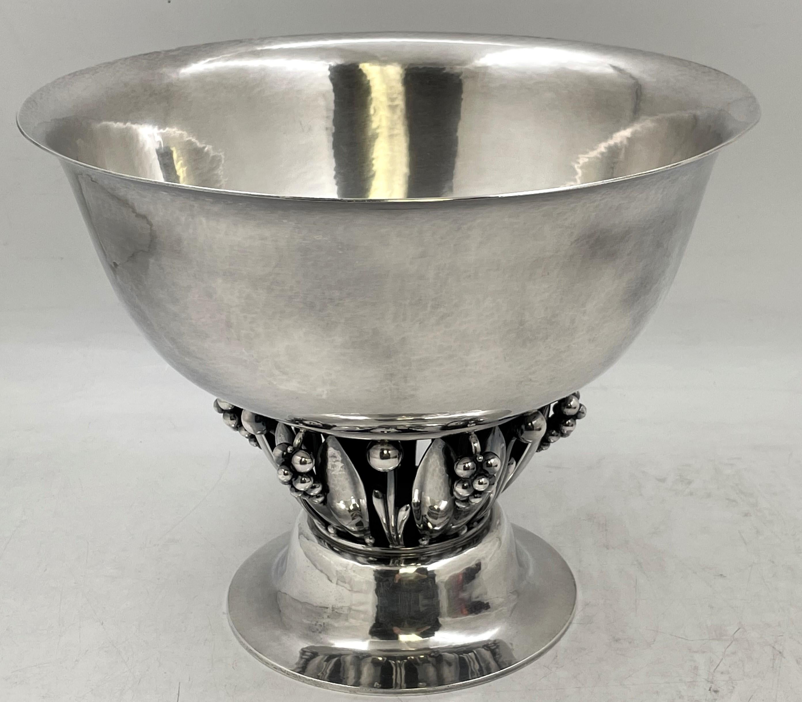 Grande ciotola da centro in argento sterling di Georg Jensen, modello 197C, splendidamente martellata a mano, con motivi naturali stilizzati che ricordano lo stile Art Nouveau e poggiata su una base circolare a gradini, risalente al XX secolo.