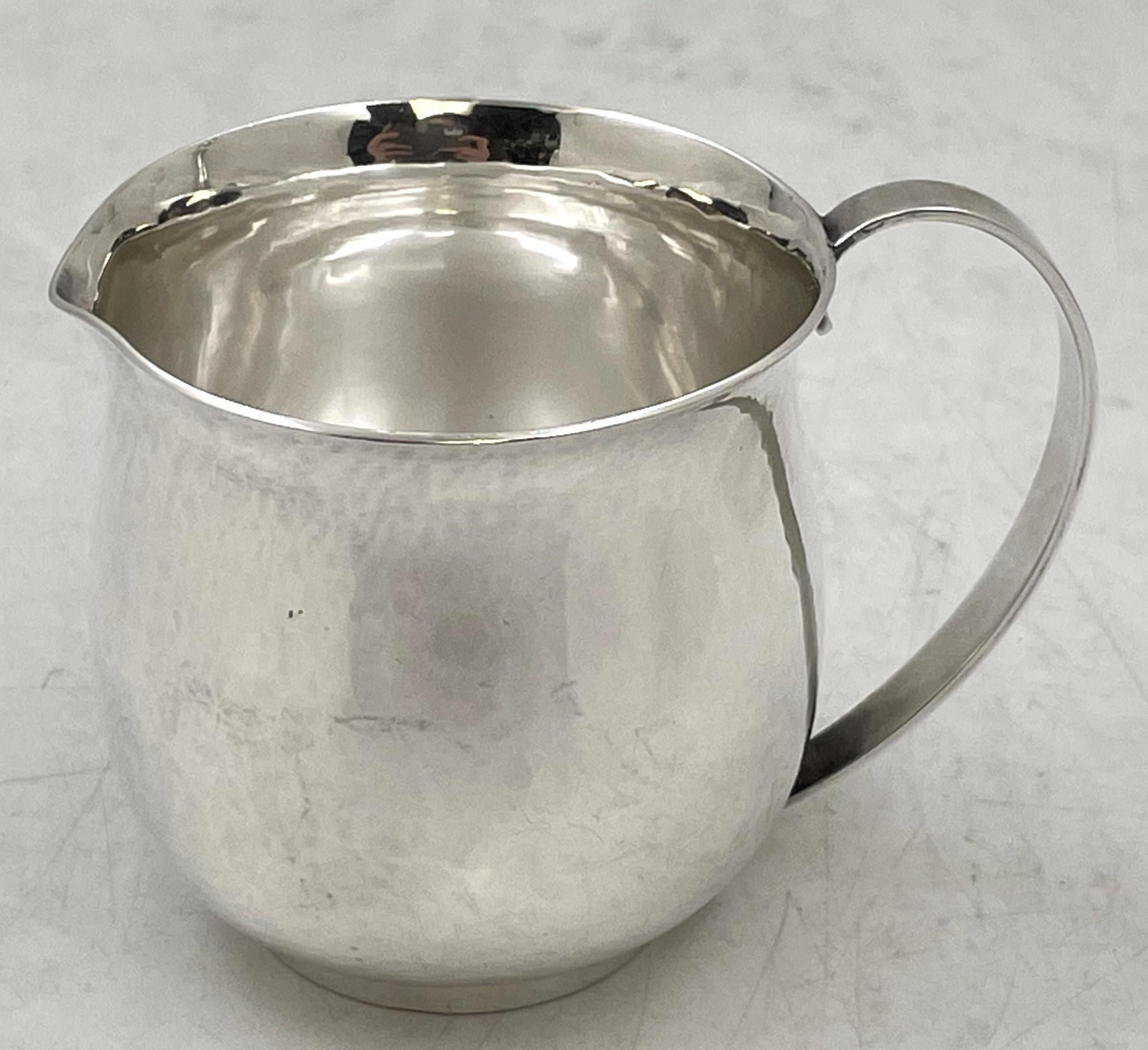 Cremiera o brocca personale in argento sterling di Georg Jensen, splendidamente martellata a mano, con il motivo numero 527 e un elegante disegno geometrico. Misura 2 2/3'' di altezza per 3 1/2'' dal manico al beccuccio, pesa 4,2 once troy e reca i