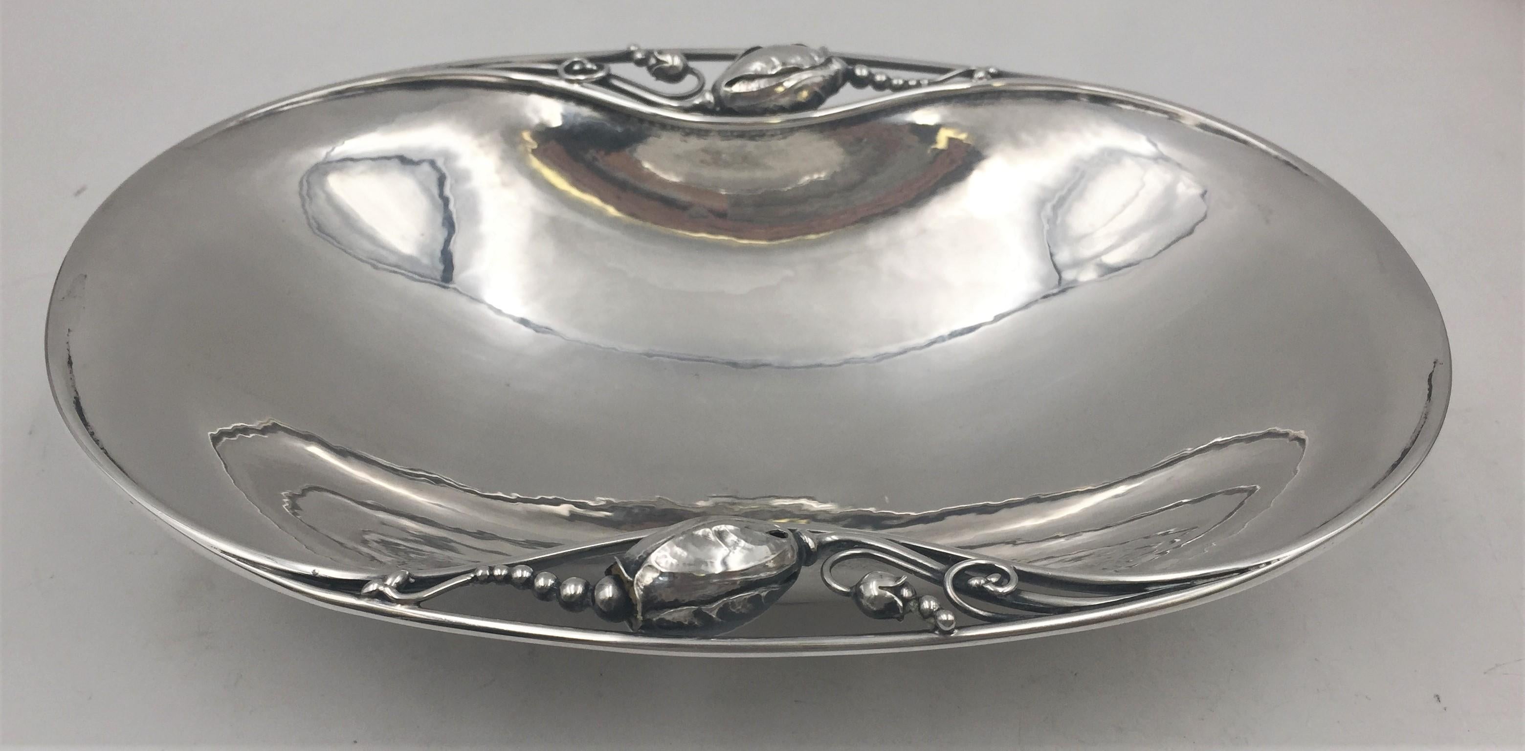 Georg Jensen sterling silver, hand hammered condiment / nut dish in Blossom pattern number 2, from after 1945. This beautiful dish, whose design is flowing and riveting, displays exquisite floral motifs on either end. It measures 8'' in length by 5