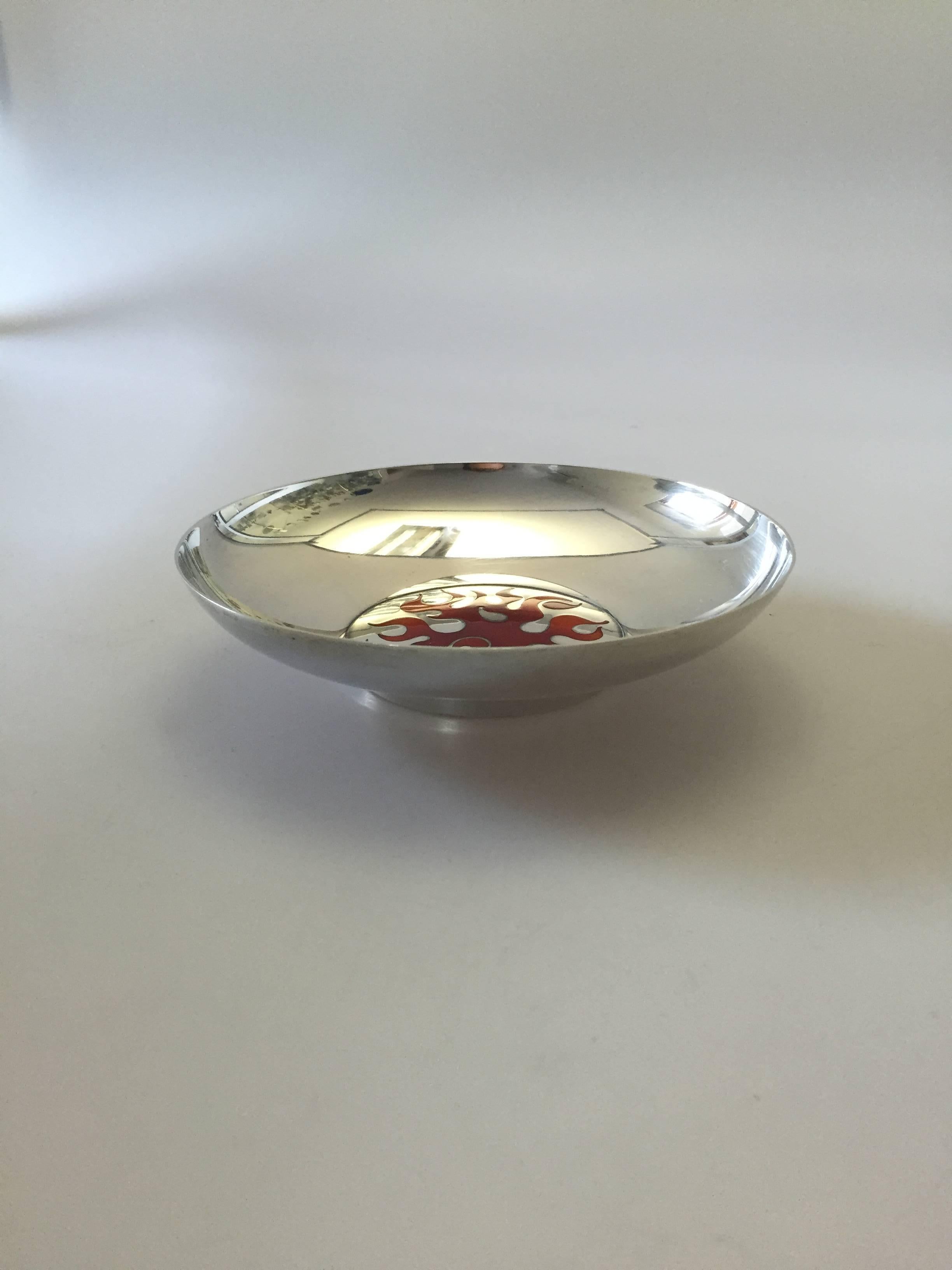 Georg Jensen sterling silver Henning Koppel bowl with red and orange enamel fire print at the bottom of the silver bowl, post 1945.

Henning Koppels (1918-1981) modern designs broke new ground for Georg Jensen. His designs were constructed in