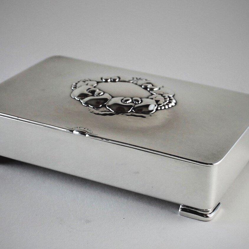 Georg Jensen sterling silver keepsake box, No. 507B by Gundorph Albertus

Elegant flower top and feet.

A similar example can be seen in the book Georg Jensen Holloware, The Silver Fund Collection by David Taylor and Jason Laskey, pg