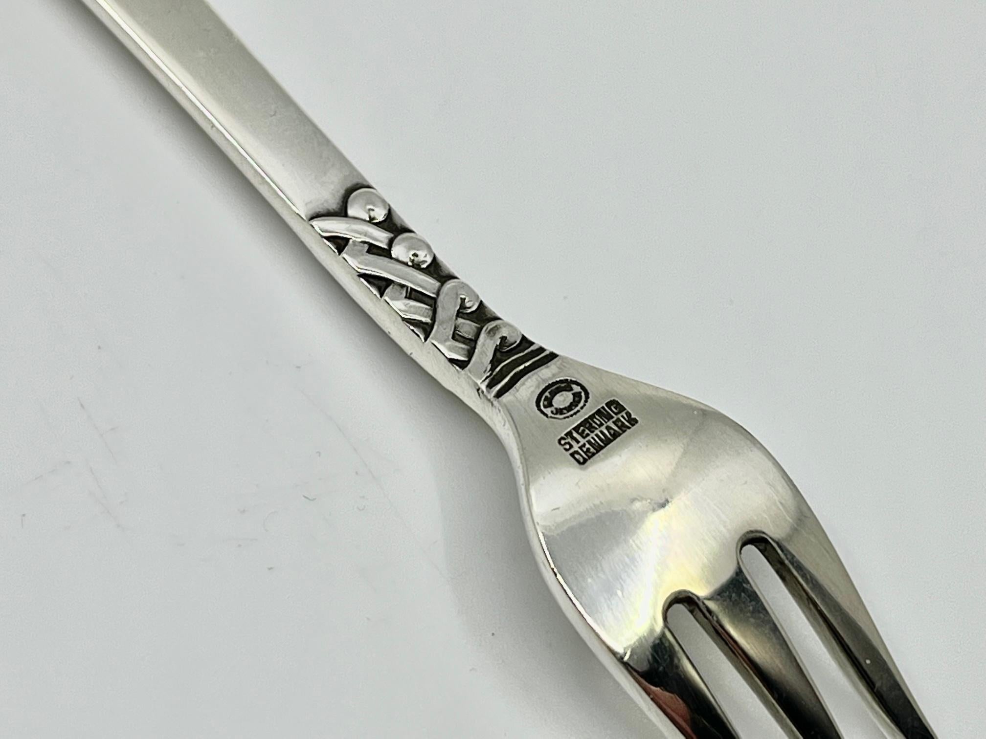 Sterling silver Georg Jensen seafood cocktail/oyster fork, item #064 in the Ladby/Nordic pattern, design #76 by Oscar Gundlach-Pedersen from 1937.

Additional information:
Material: Sterling silver
Styles: Art Deco
Hallmarks: With Georg Jensen
