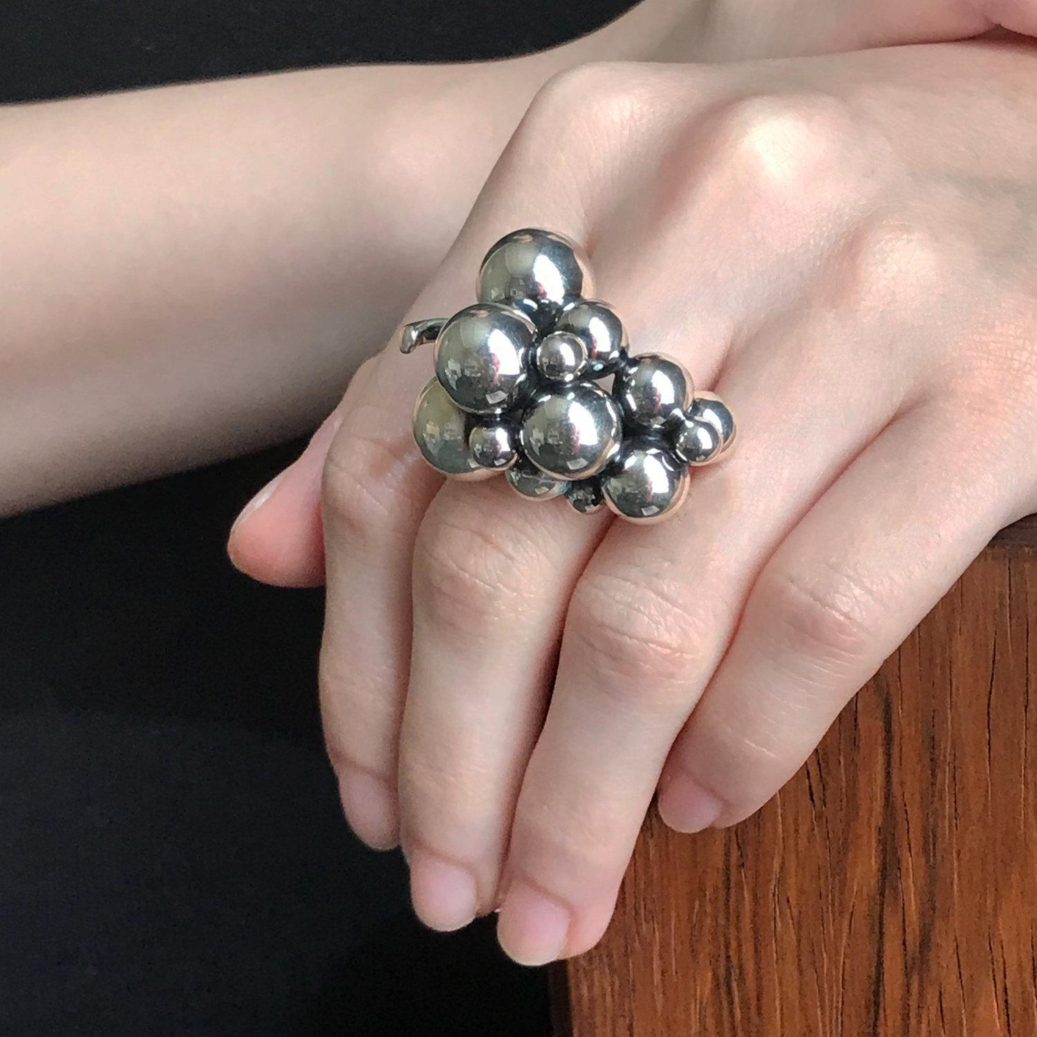 Georg Jensen Sterling Silver Large Grape Ring.  Size 7.5, Adjustable

Bold statement piece. This is the largest of this design.    

Designer: Georg Jensen
Maker: Georg Jensen
Design #: N/A
Morden Production
Dimensions:  1’’ W x 1.5’’
              