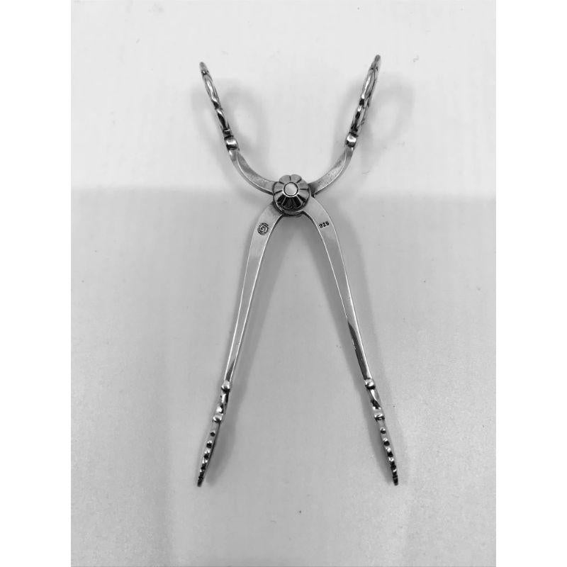Sterling silver Georg Jensen sugar tongs, item 174 in the Lily of the Valley pattern, design #1 by Georg Jensen from 1913.

Additional information:
Material: Sterling silver
Styles: Art Nouveau
Hallmarks: With Georg Jensen hallmark, made in