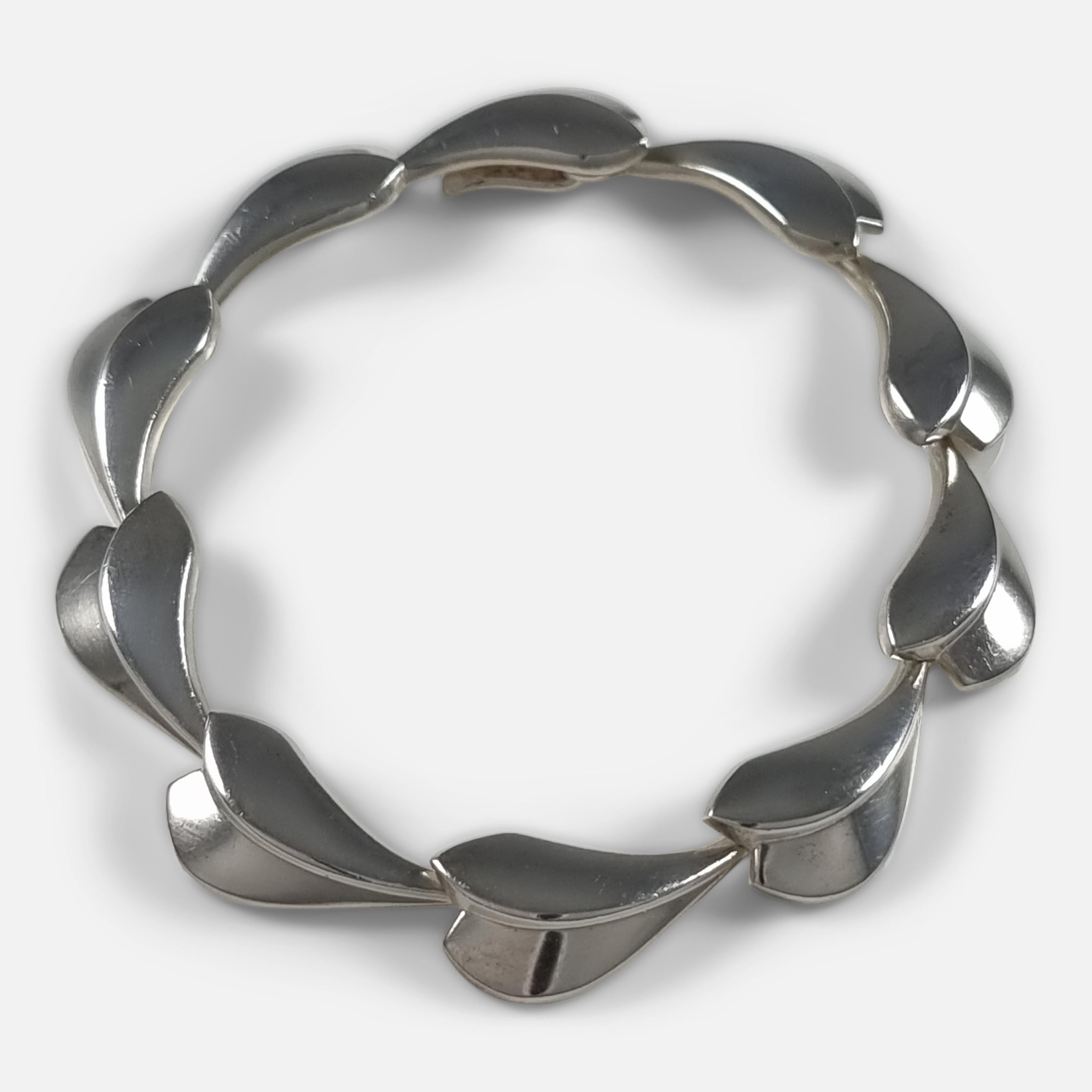 A sterling silver 'Lotus' Bracelet, designed by Per Hertz for Georg Jensen.

Stamped with post-1945 Georg Jensen marks, '925S Denmark', and with Danish Common Control Marks for sterling silver.

Period: - Early 21st century.

Engraving: -