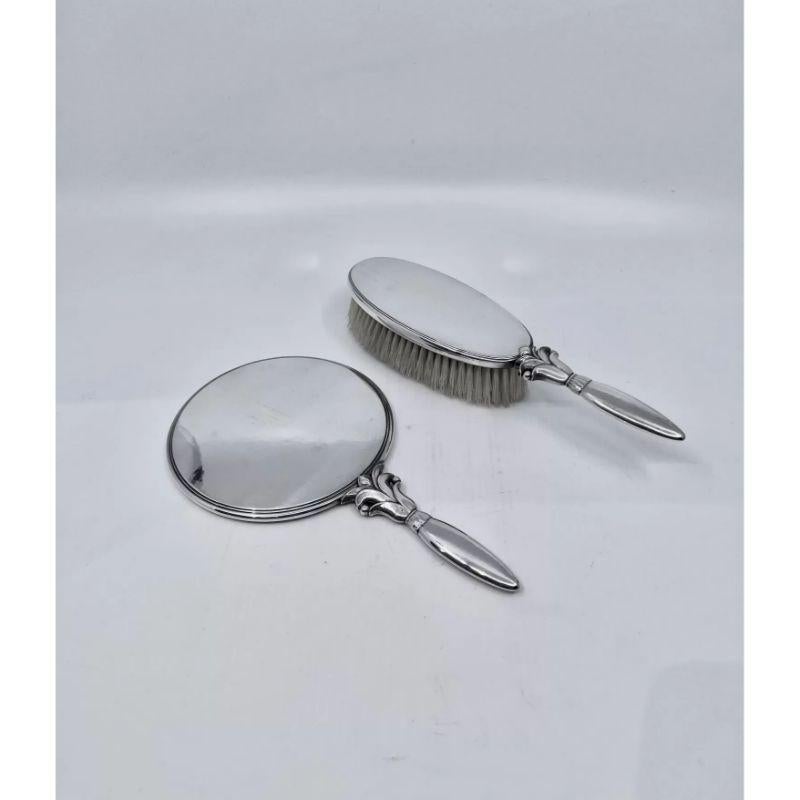 A sterling silver Georg Jensen matching Mirror and Brush, designed by Harald Nielsen in 1932. The art deco set includes a hairbrush and a hand mirror, both in excellent condition. The brush has a floral motif handle attached and oval silver head,