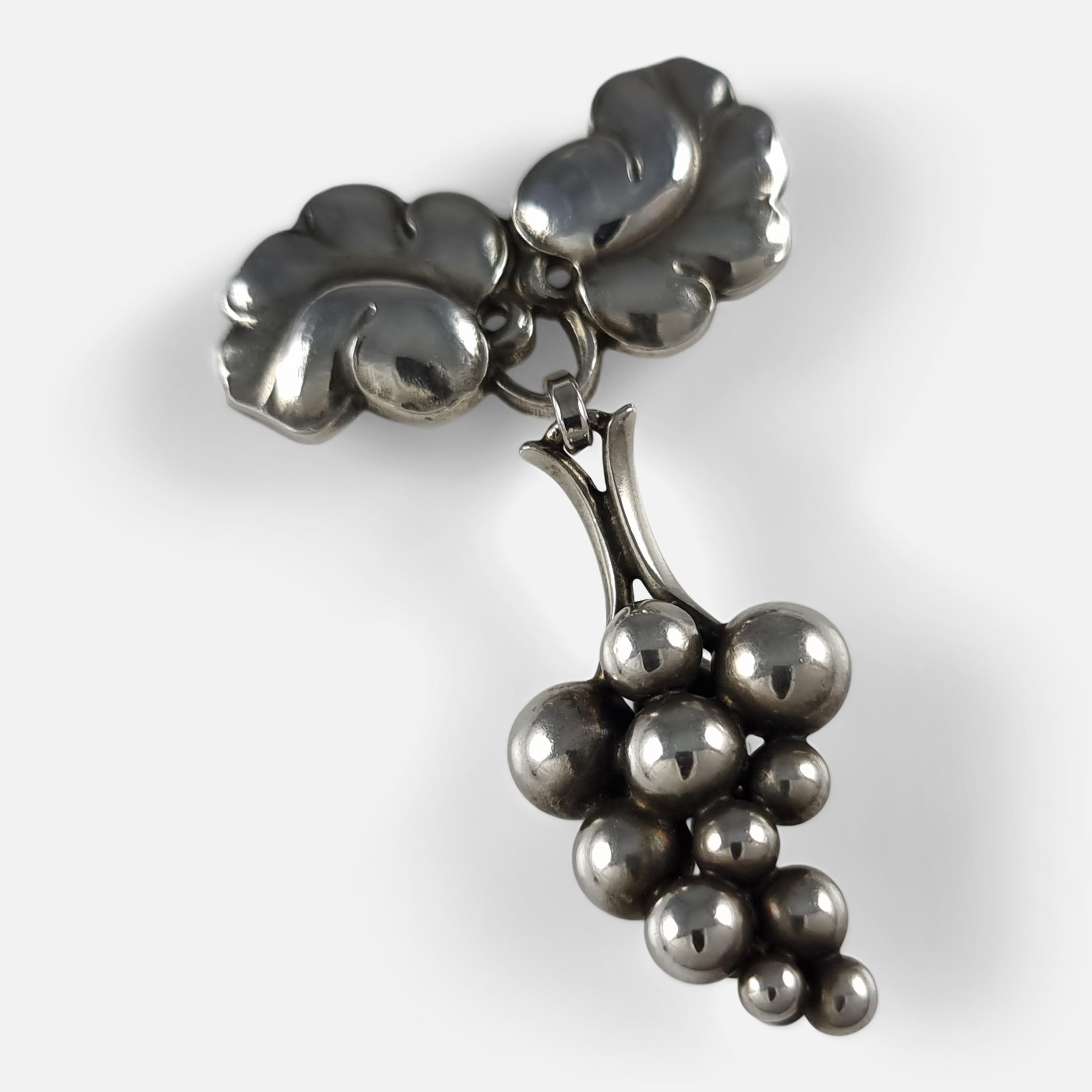 A Georg Jensen sterling silver moonlight grapes brooch, design #217 B. The brooch is designed by Harald Nielsen for Georg Jensen.

Stamped Georg Jensen within dotted oval mark, '925S', and 'Denmark'.

The brooch is UK hallmarked, stamped '925' to