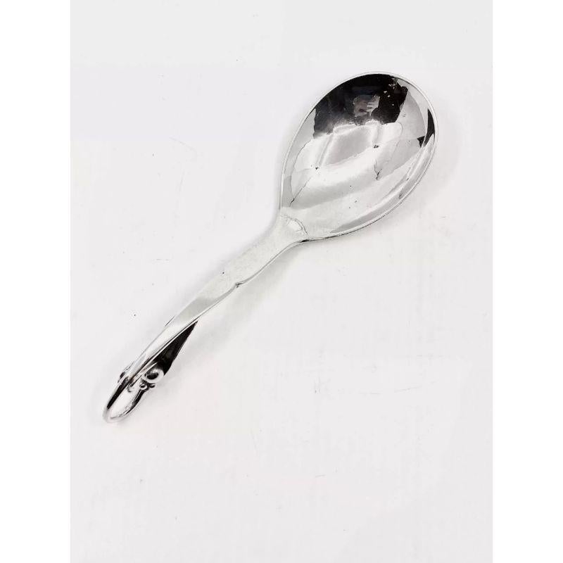 A sterling silver Georg Jensen jam spoon, Ornamental pattern #21 by Georg Jensen from 1912.A hand hammered curved spoon, with pea pod decoration on handle. The bowl is an oval shape that was handcrafted.

Additional information:
Material: Sterling