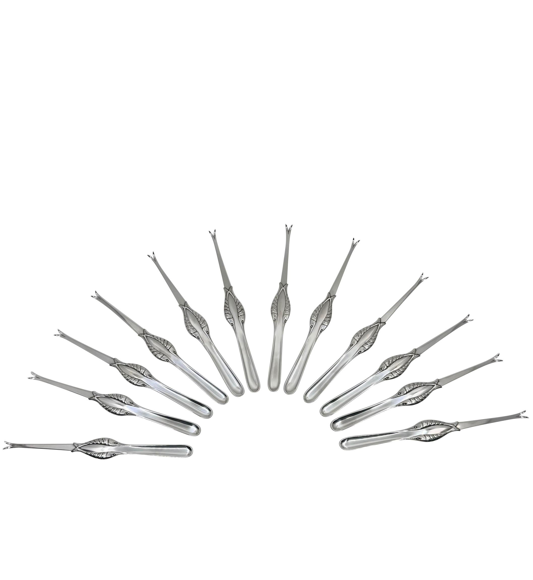 A set twelve Georg Jensen sterling silver lobster picks/forks, featuring the ornamental Pattern #86 crafted by Georg Jensen in 1930. Handmade at the Georg Jensen silver smithy in Denmark, each piece has a two-pronged fork adorned with meticulously