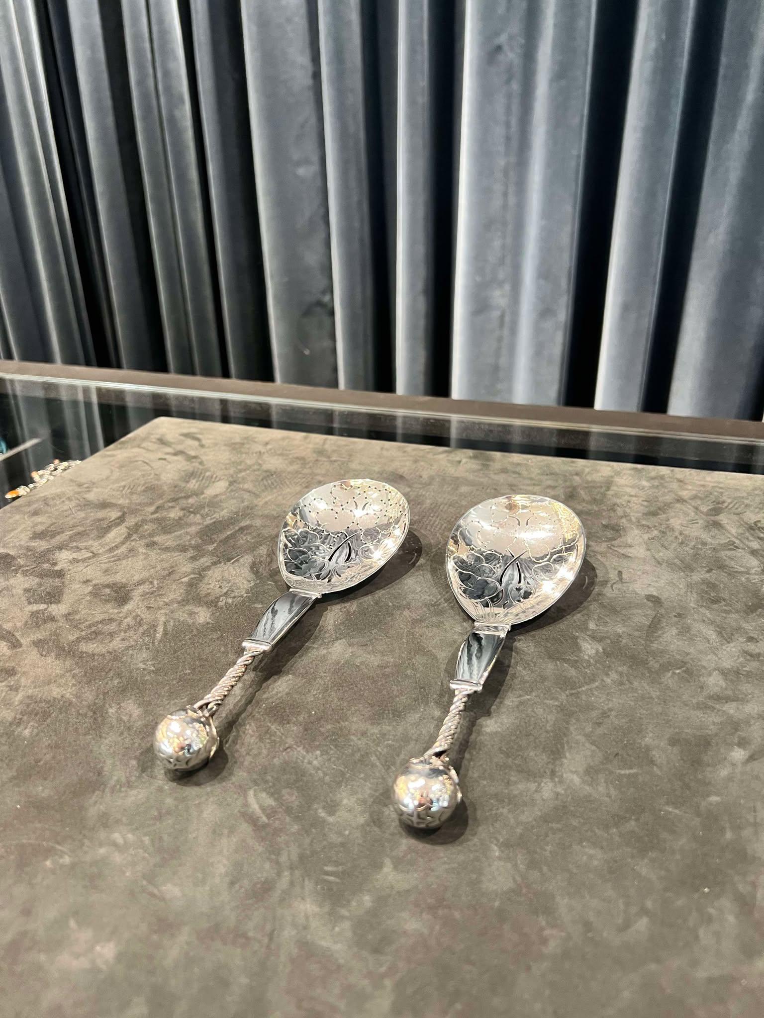 Ein silbernes Georg Jensen Erdbeerlöffel-Set, Design #35 von Georg Jensen. Die Schale des Löffels hat erstaunliche handziselierte florale Details und ist mit einem handgeschnittenen Muster versehen, damit der Beerensaft ablaufen kann. Der Mittelteil