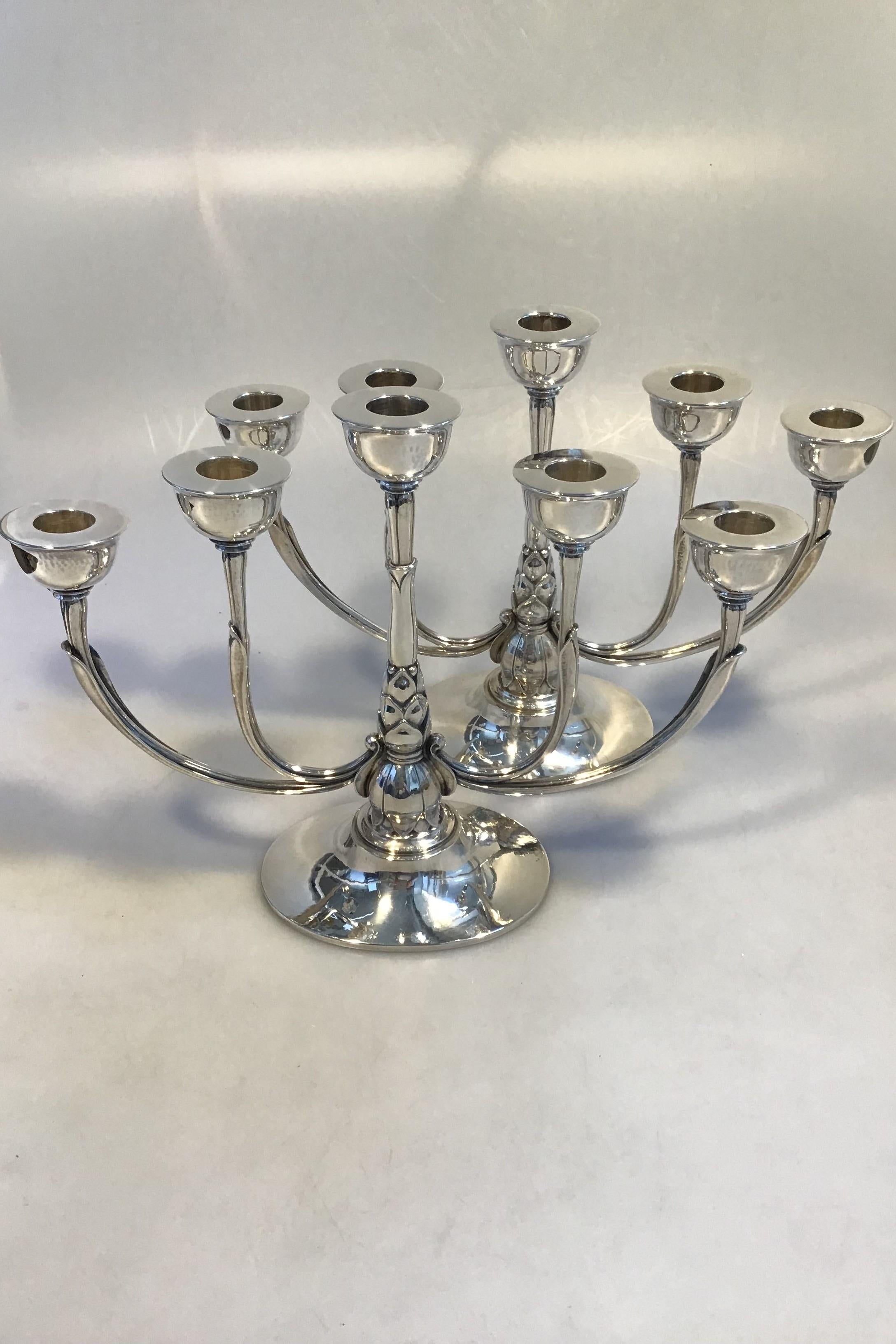 Georg Jensen sterling silver pair of five-branch candelabra No 537A(2)
(1925-1933) design Harald Nielsen 

Measures: H 23 cm (9.05 in), W 32 cm(12.59 in) 
Combined weight 1977gr (69.73 oz).