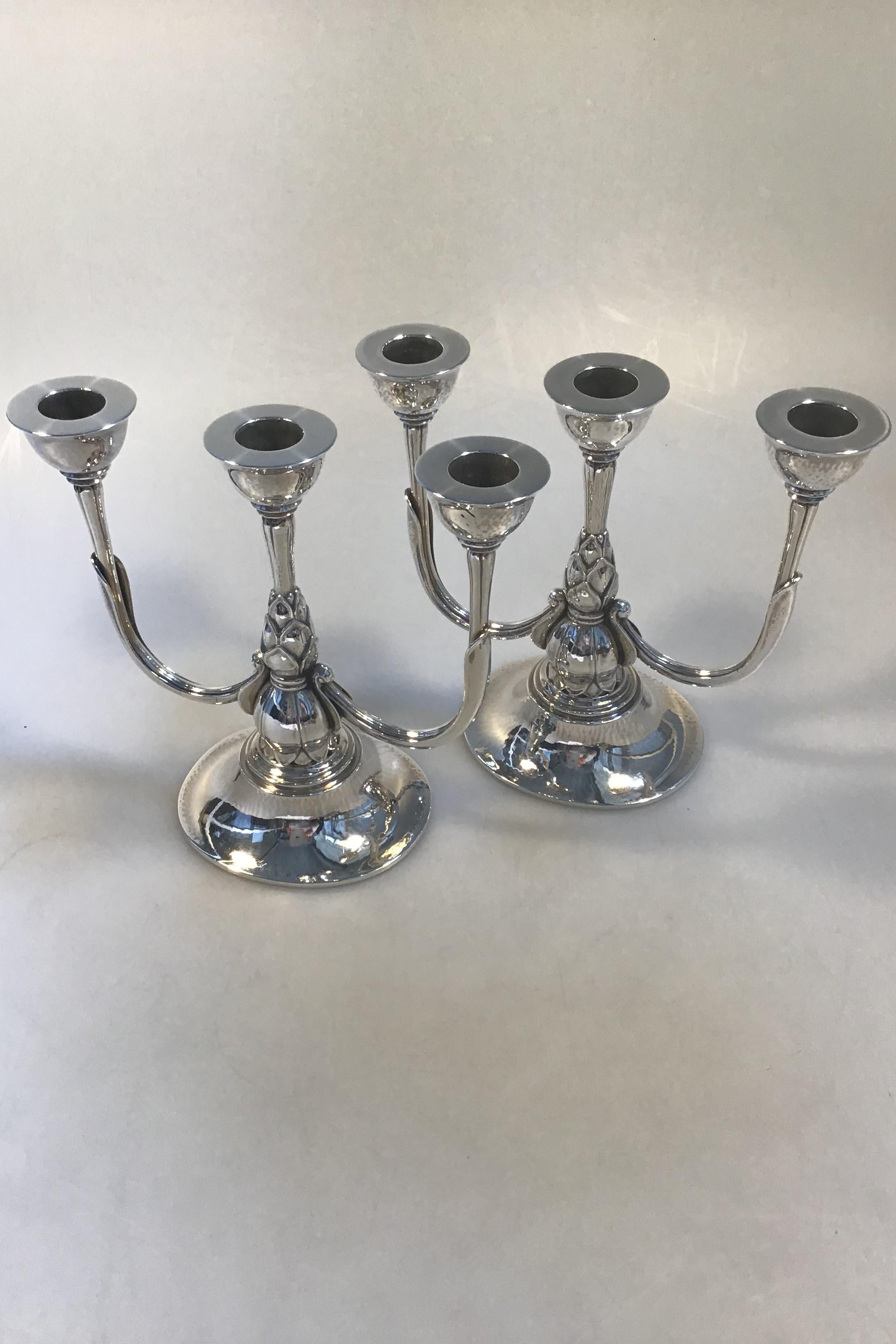 Georg Jensen sterling silver pair of three-branch candelabra No 537B(2)
(1925-1933) design Harald Nielsen 

Measures: H 18 cm (7.08 in), W 20 cm(7.87 in) 
Combined weight 1185gr (41.80 oz).