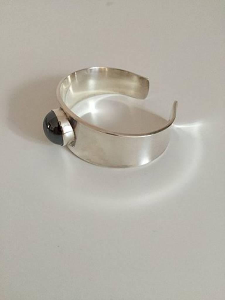 Georg Jensen Sterling Silver Bangle Bracelet #188 designed by Paul Hansen. Ornamented with hematite. From after 1945.
Diameter measures 6 cm / 2 23/64 in. Weighs 60 g / 2.11 oz