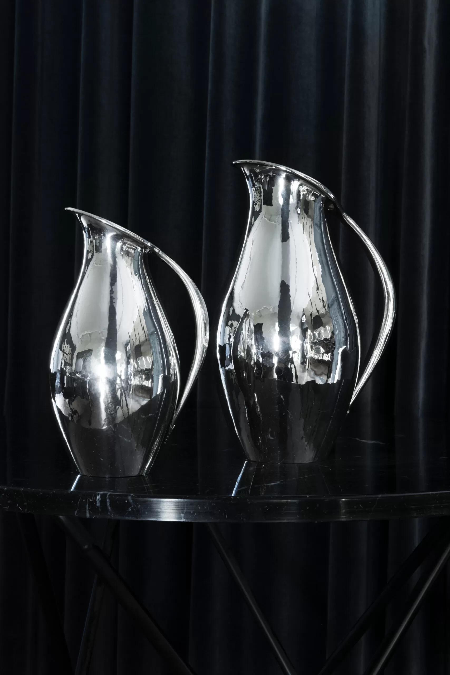The Georg Jensen sterling silver pitcher, design #432A, was conceived by the renowned artist Johan Rohde in 1920. Known for its timeless elegance and innovative minimalist aesthetic, this iconic piece stands as a testament to Rohde's visionary