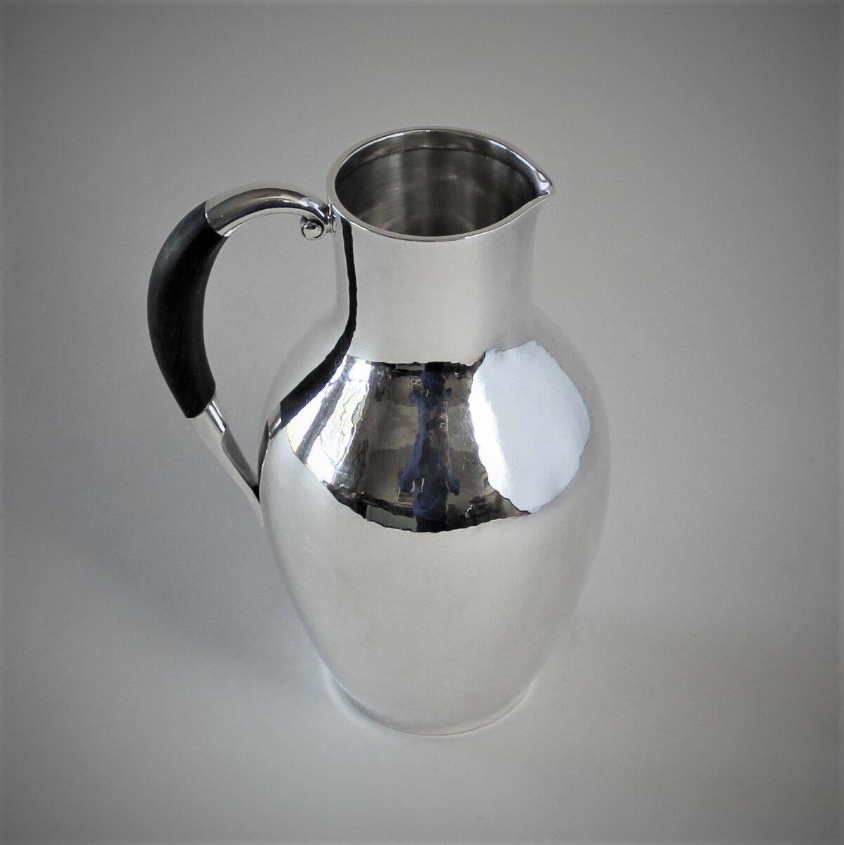 Georg Jensen sterling silver pitcher with ebony handle, No.743 by Johan Rohde

A similar example can be seen in the book Georg Jensen Holloware, The Silver Fund Collection by David Taylor and Jason Laskey, pg 248.

Designer: Johan Rohde
 Maker:
