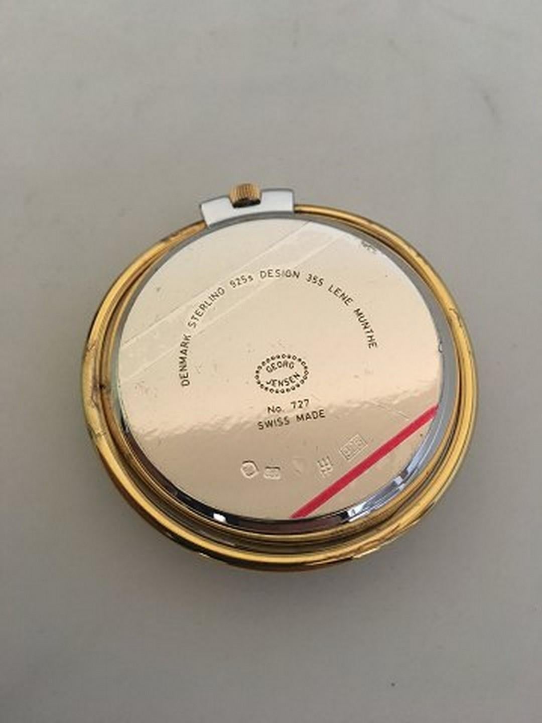 Georg Jensen Sterling Silver Pocket watch / Table watch No. 355 designed by Lene Munthe. With gilded round circle / standing mechanism. Weighs 89 grams (3.15 oz). Meaures 5.5 cm diameter (2 11/64