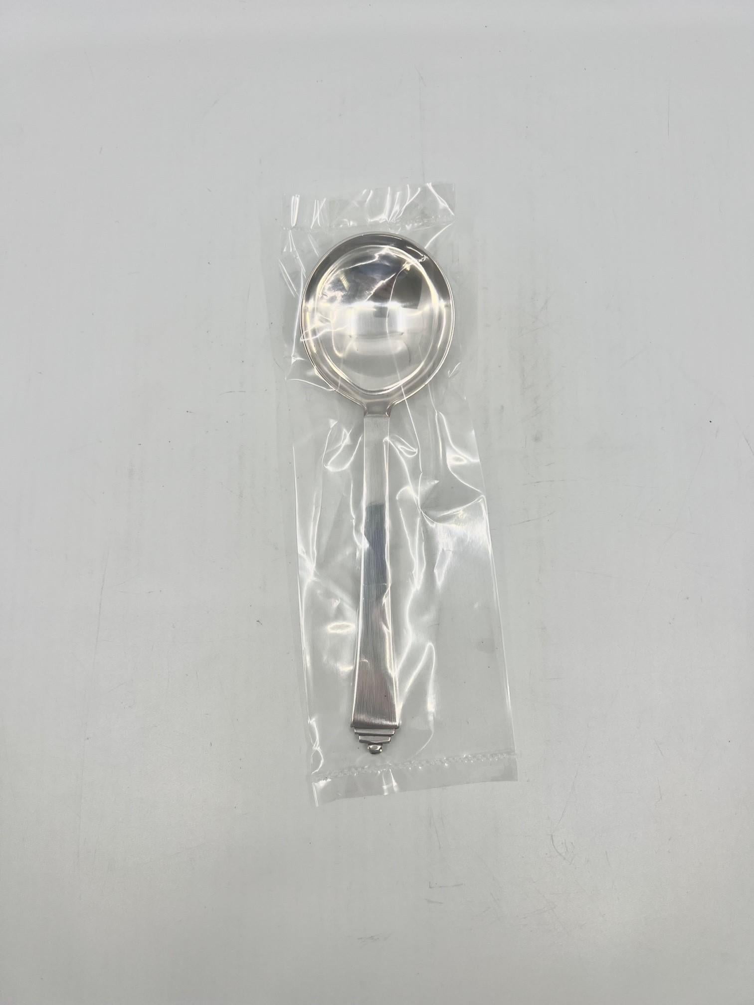 A sterling silver Georg Jensen bouillon spoon, item #053 in the Pyramid pattern, design #15 by Harald Nielsen from 1926. These spoons are no longer produced.

Additional information:
Material: Sterling silver
Styles: Art Deco
Hallmarks: With post
