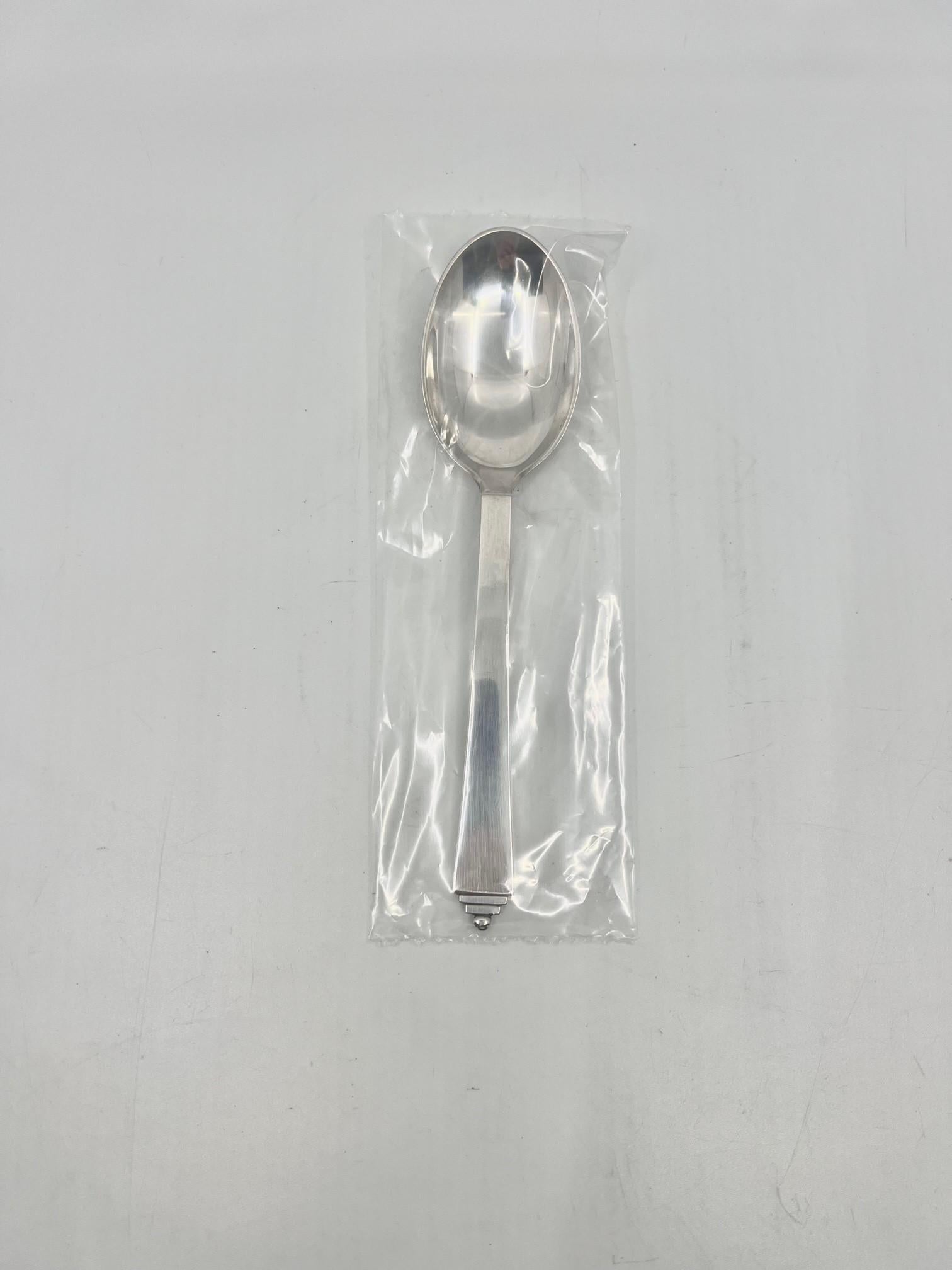 A sterling silver Georg Jensen dessert spoon, item 021 in the Pyramid pattern, design #15 by Harald Nielsen from 1926.

Additional information:
Material: Sterling silver
Styles: Art Deco
Hallmarks: We currently have many of these spoons, most of