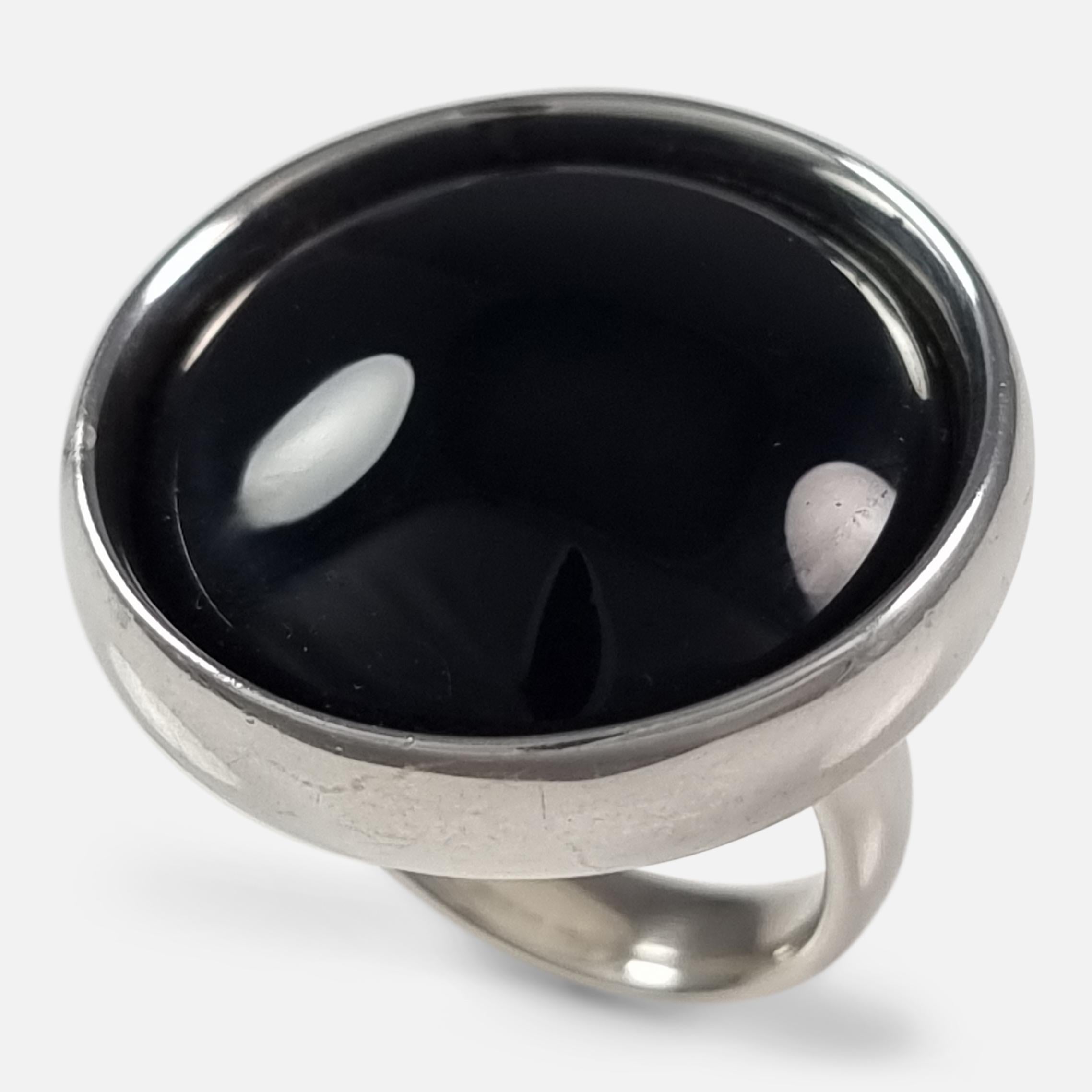A Georg Jensen sterling silver and black onyx ring #466, design by Regitze Overgaard. 

Stamped 'GJ', '925 S', & '466'. The ring is hallmarked with London marks, 2012.

Period: - Early 21st Century.

Engraving: - Unengraved.

Maker: - Georg