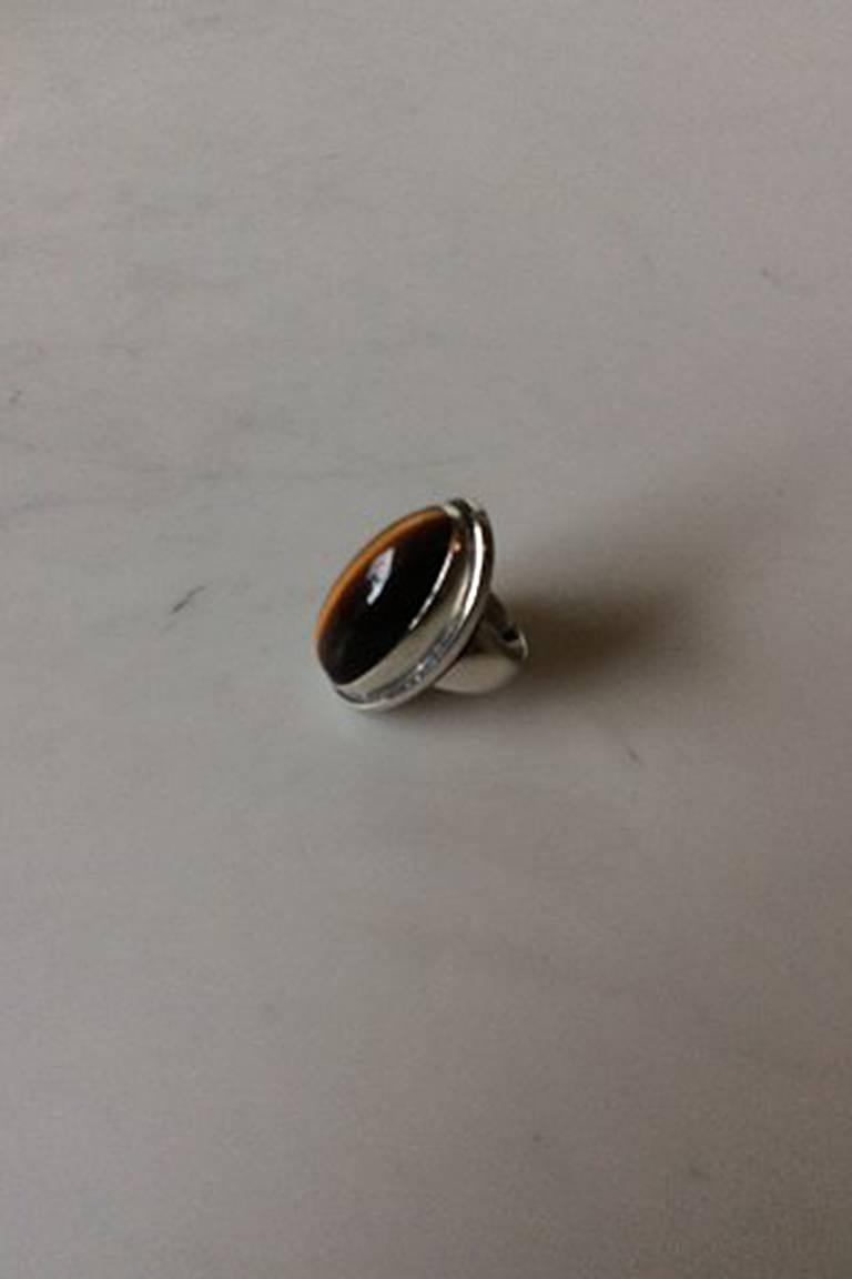 Georg Jensen Sterling Silver Ring with Tiger's eye No 46E.
Ring Size 56 / US 7 1/2.
Measures 3.5 cm / 1 3/8 in.
Weight is 19 gram / 0.676 oz.
